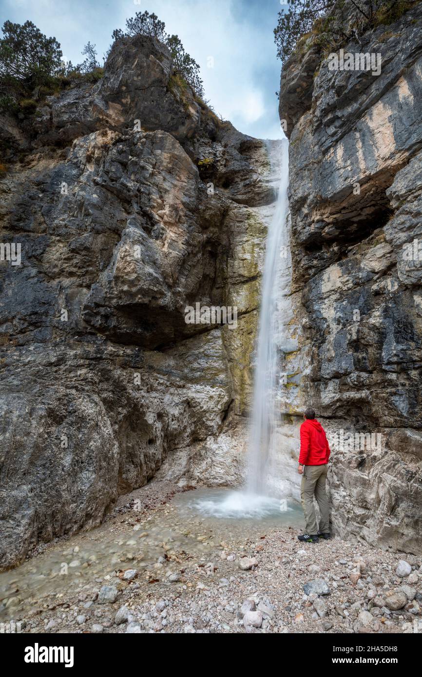 Einsamer Wanderer beobachtet einen kleinen Wasserfall im Corpassa-Tal, der vom triester Turm, der civetta-Gruppe, den dolomiten, taibon agordino, der Provinz belluno, venetien, italien dominiert wird Stockfoto Einsamer Wanderer beobachtet einen kleinen Wasserfall im Corpassa-Tal, der vom triester Turm, der civetta-Gruppe, den dolomiten, taibon agordino, der Provinz belluno, venetien, italien dominiert wird Stockfoto