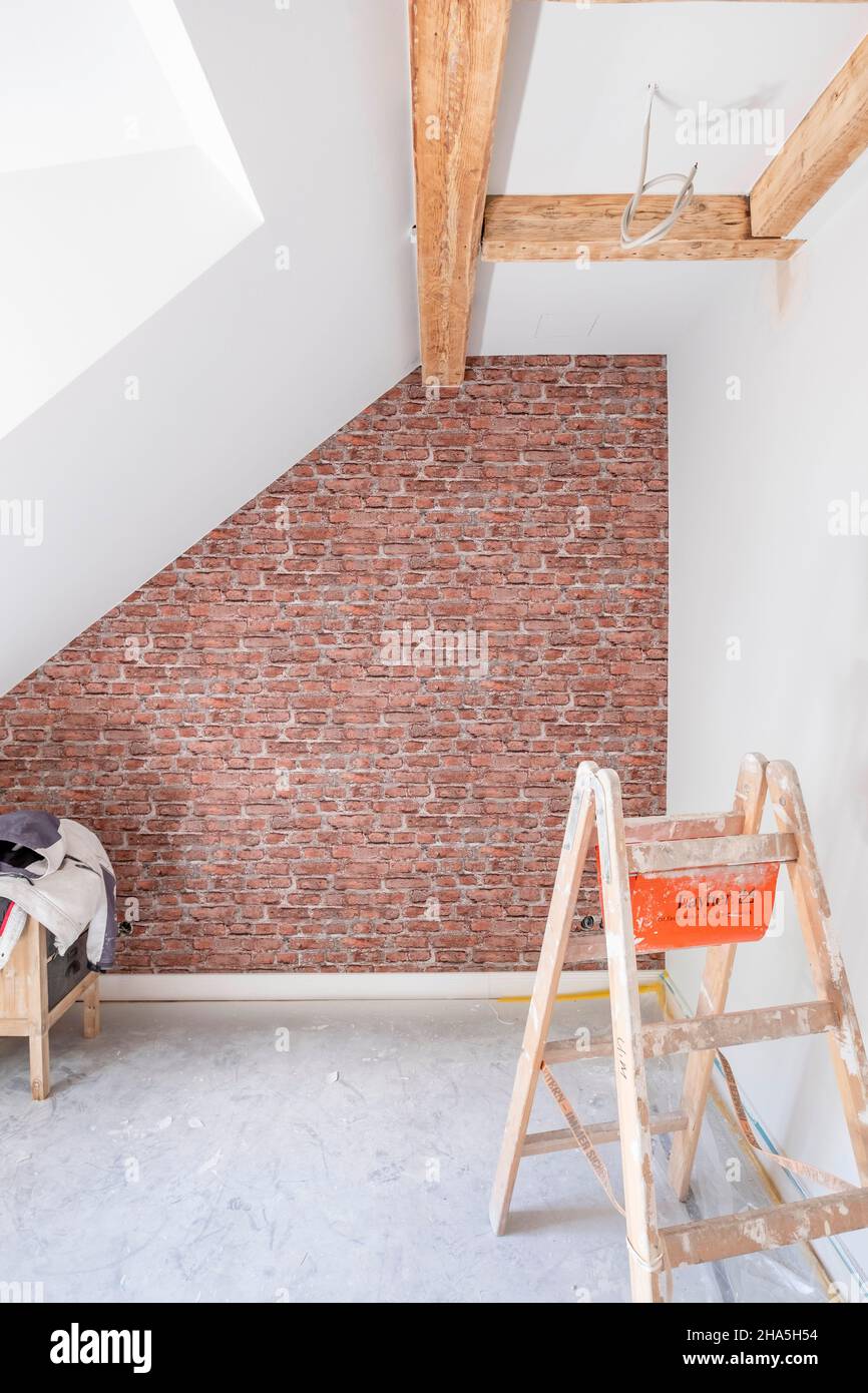 Baustelle, Renovierung und Renovierung einer Wohnung, leerer Raum im Dachgeschoss mit Backsteinmotivtapete Stockfoto