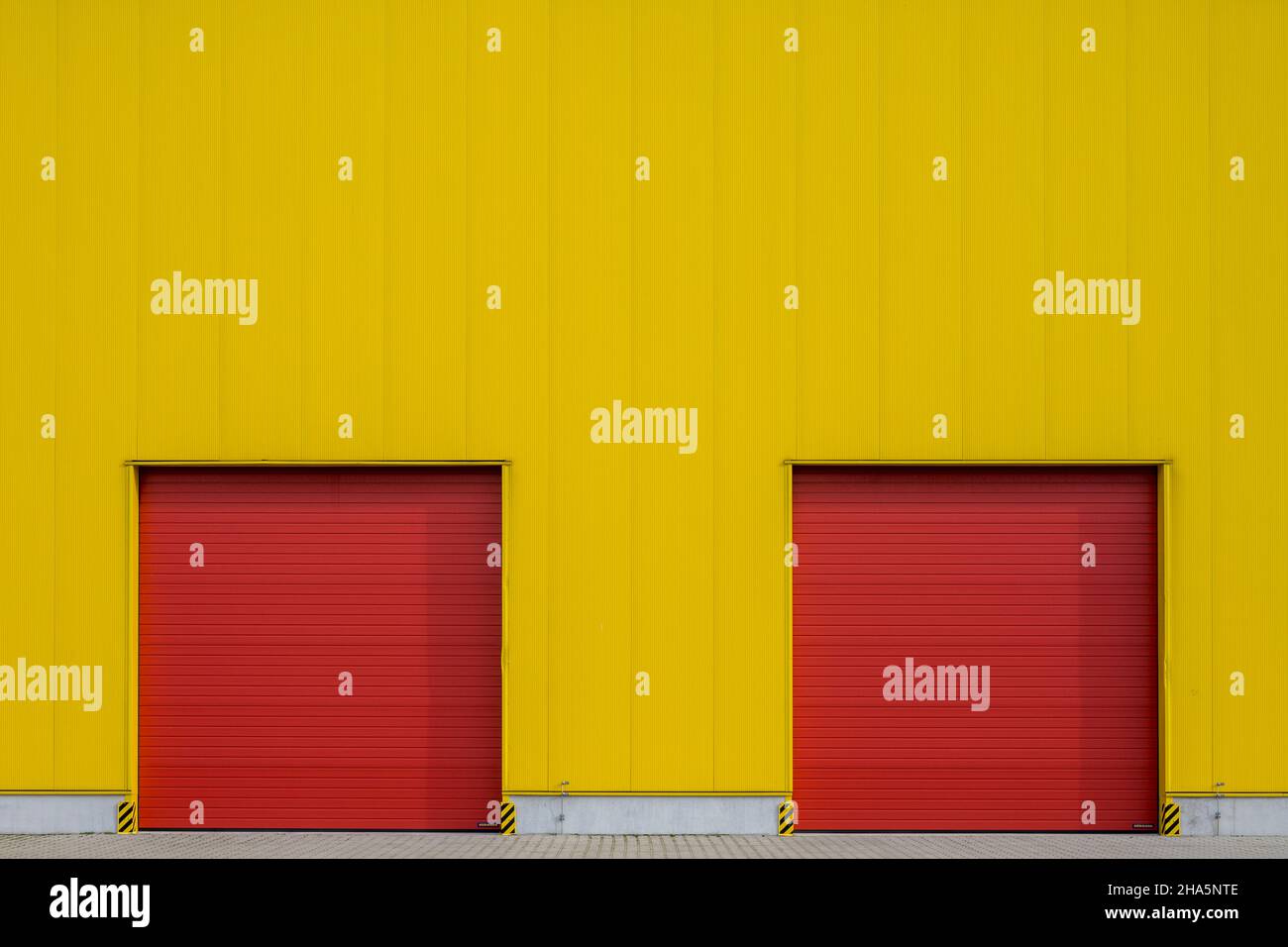 Bunte Industriearchitektur, rote Tore, gelbe Fassade, Stockfoto