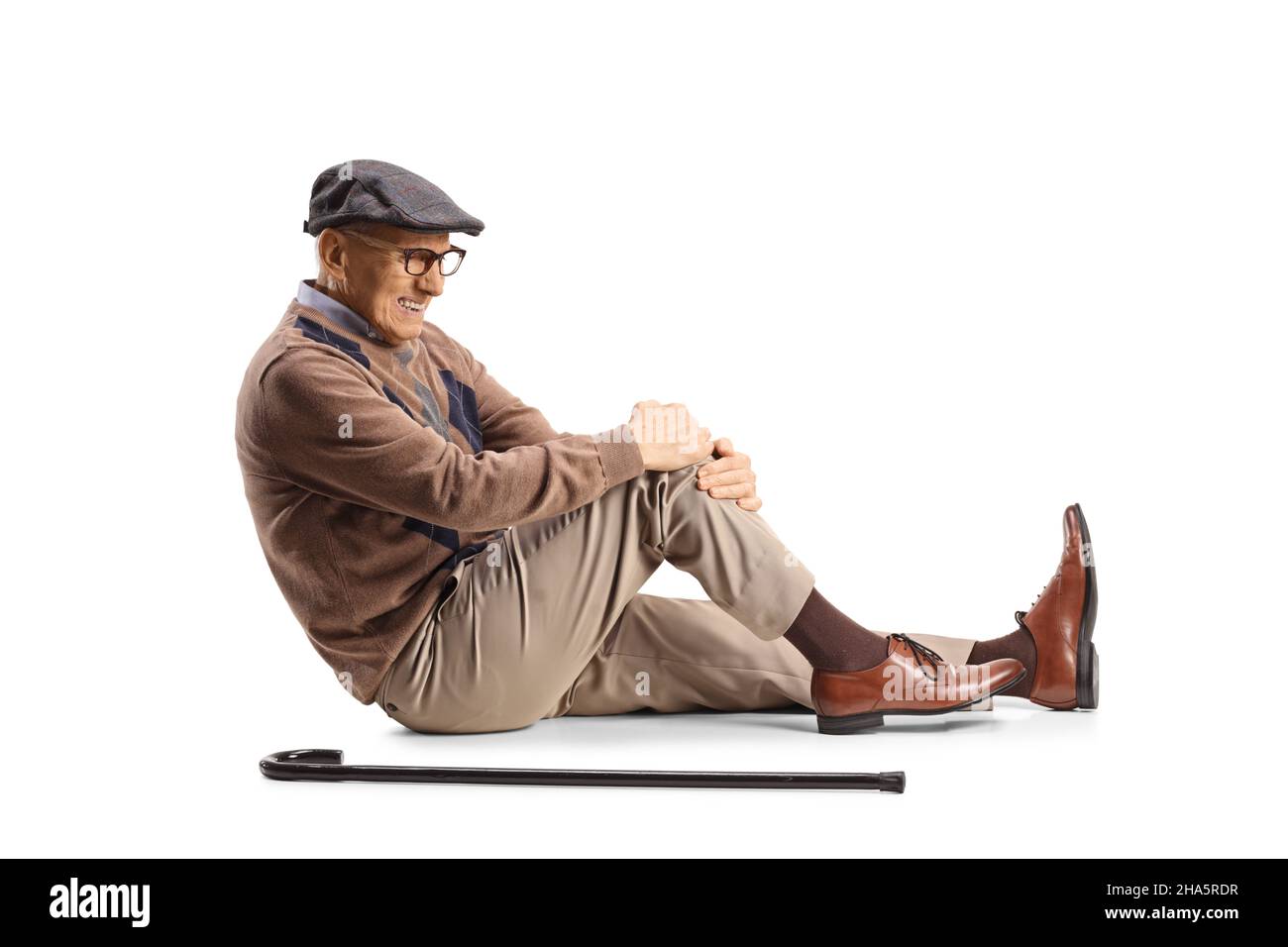 Älterer Mann auf dem Boden, der sein schmerzhaftes Knie isoliert auf weißem Hintergrund hält Stockfoto