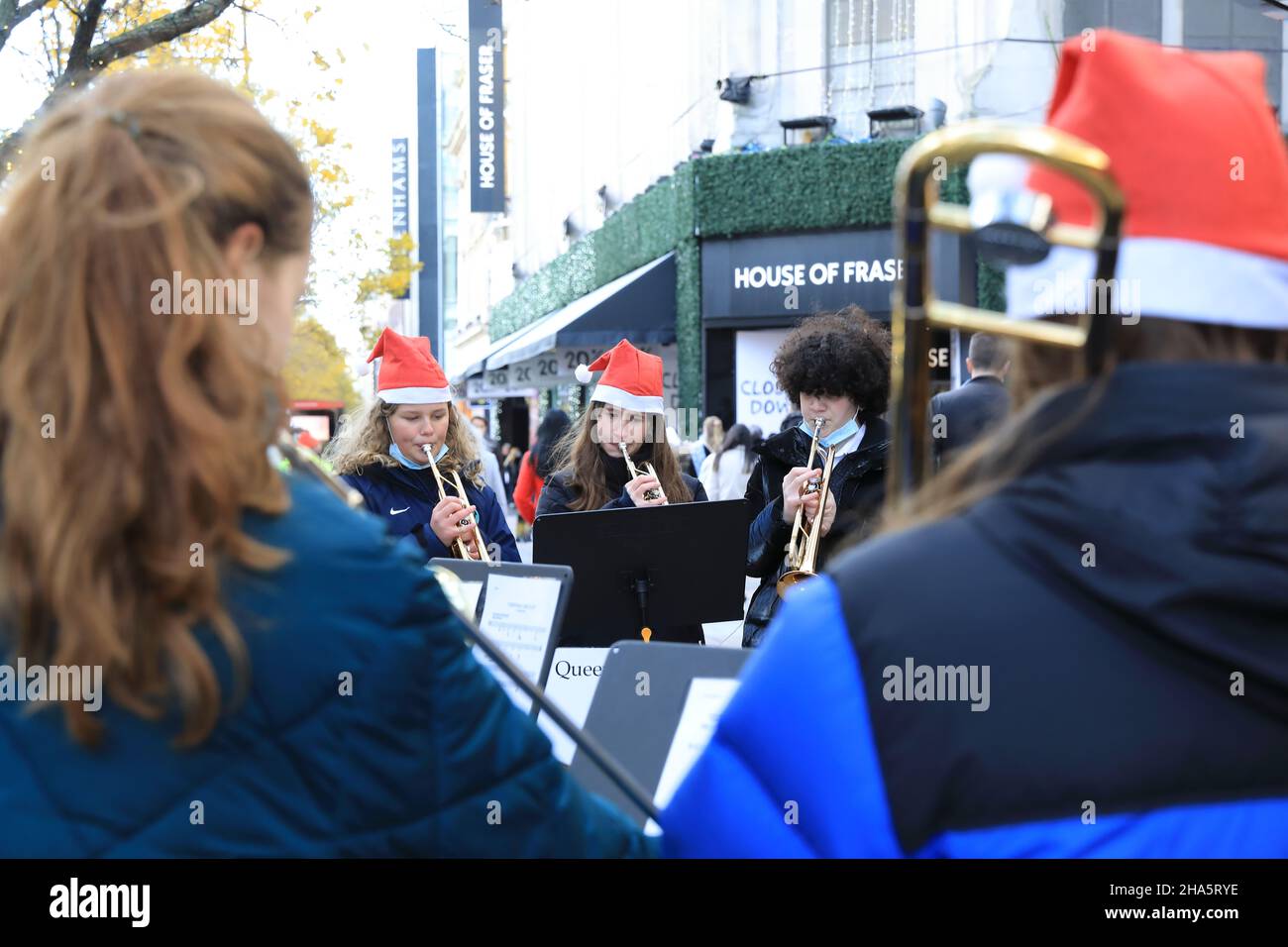 Carol singt in der Oxford Street, vor dem House of Fraser, das am 2021. Dezember geschlossen wird, West End, London, Großbritannien Stockfoto