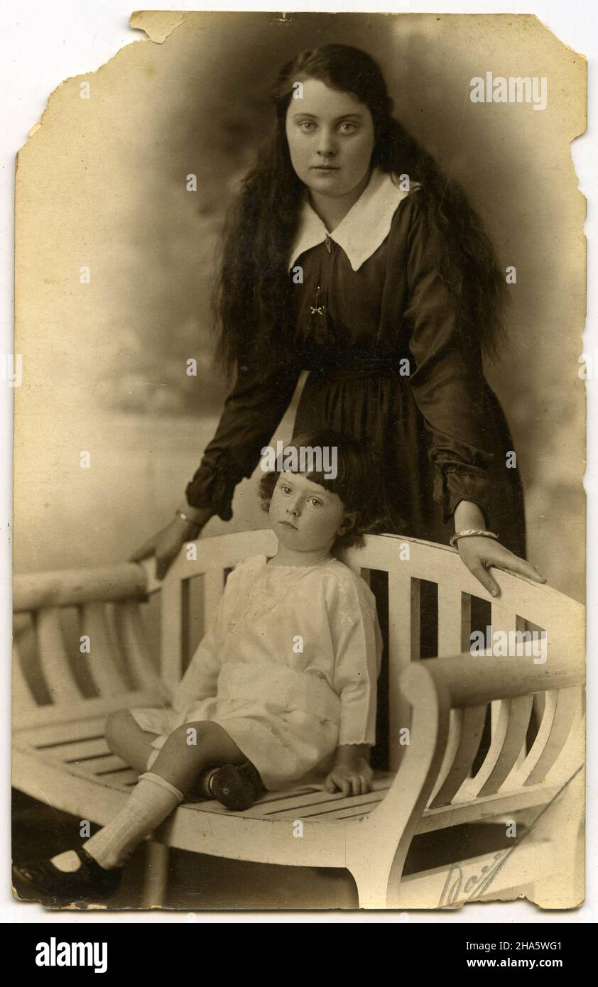 studioporträt einer bescheiden gekleideten jungen Frau mit einem Mädchen, wahrscheinlich ihrer Schwester, Stockfoto
