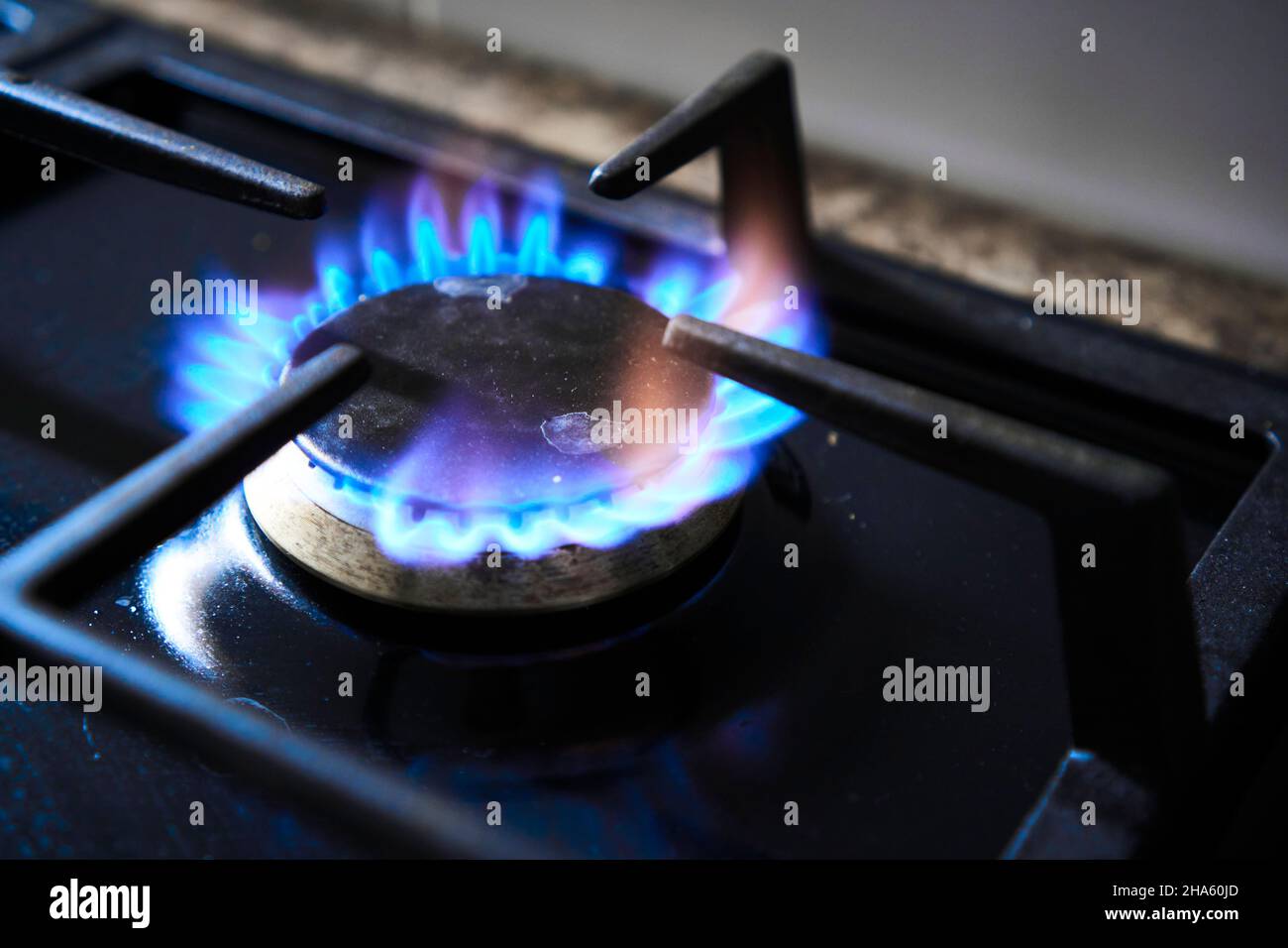Küchenherd mit Brenner, der mit brennbarem, billigem Erdgas oder Synthesegas, Propan, Butan betrieben wird. Rötliche Flamme aus einem schlechten Gaskochfeld Stockfoto