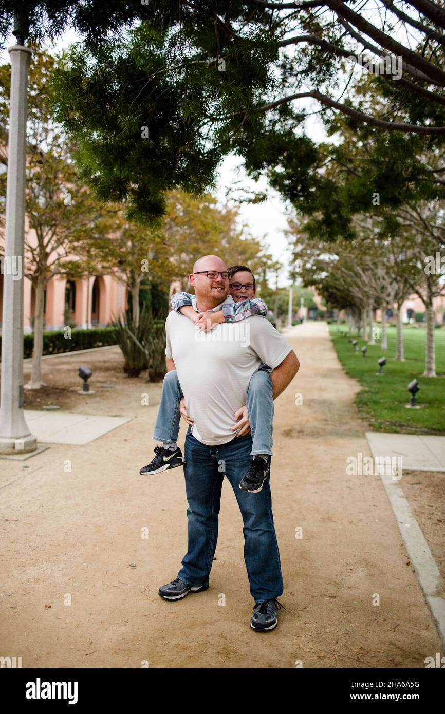 Vater gibt zehn Jahre alten Sohn eine Huckepack Fahrt in San Diego Stockfoto