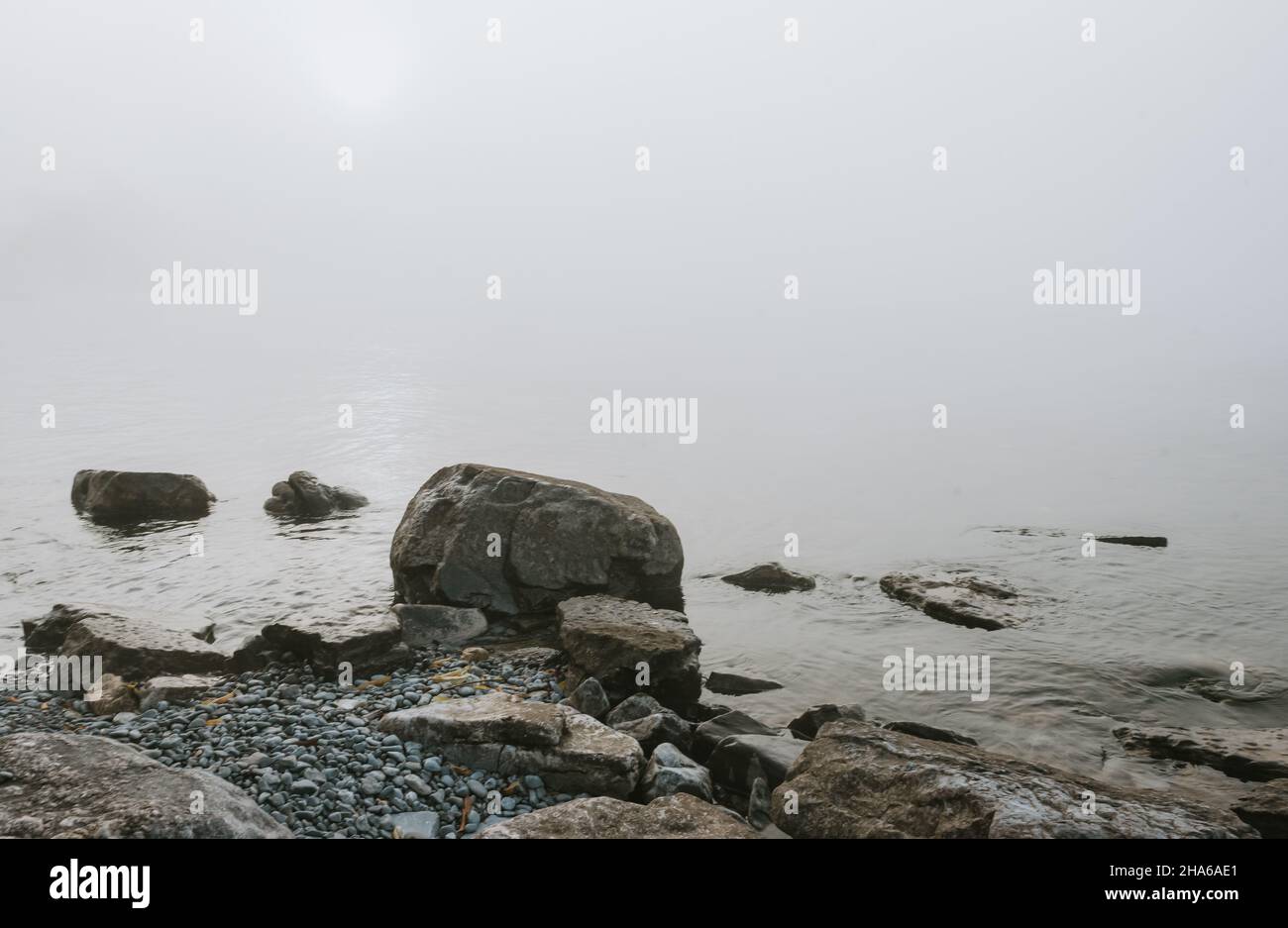 Felsiger Strand des Lake Ontario an einem grauen nebligen Tag. Stockfoto