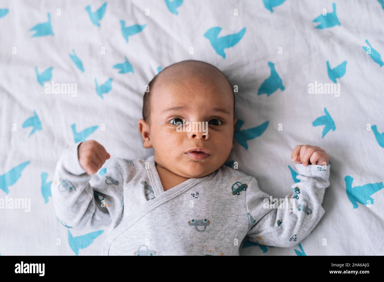 Porträt eines einen Monat alten Babys, das auf einem Bett liegt Stockfoto