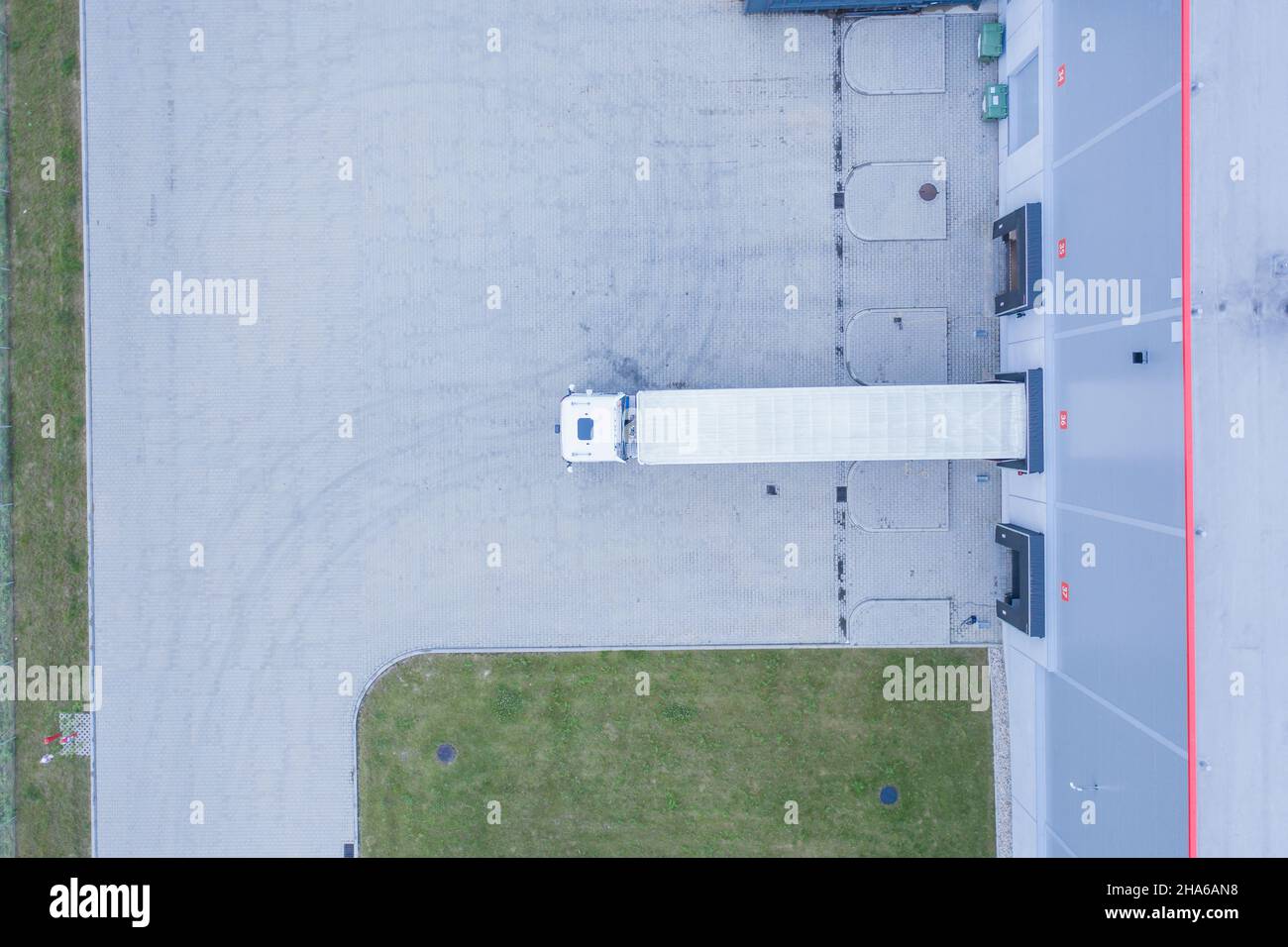 Luftaufnahme von Warenlager. Logistik Zentrum in der industriellen Zone der Stadt von oben. Luftaufnahme von Lkw beladen am Logistikzentrum Stockfoto