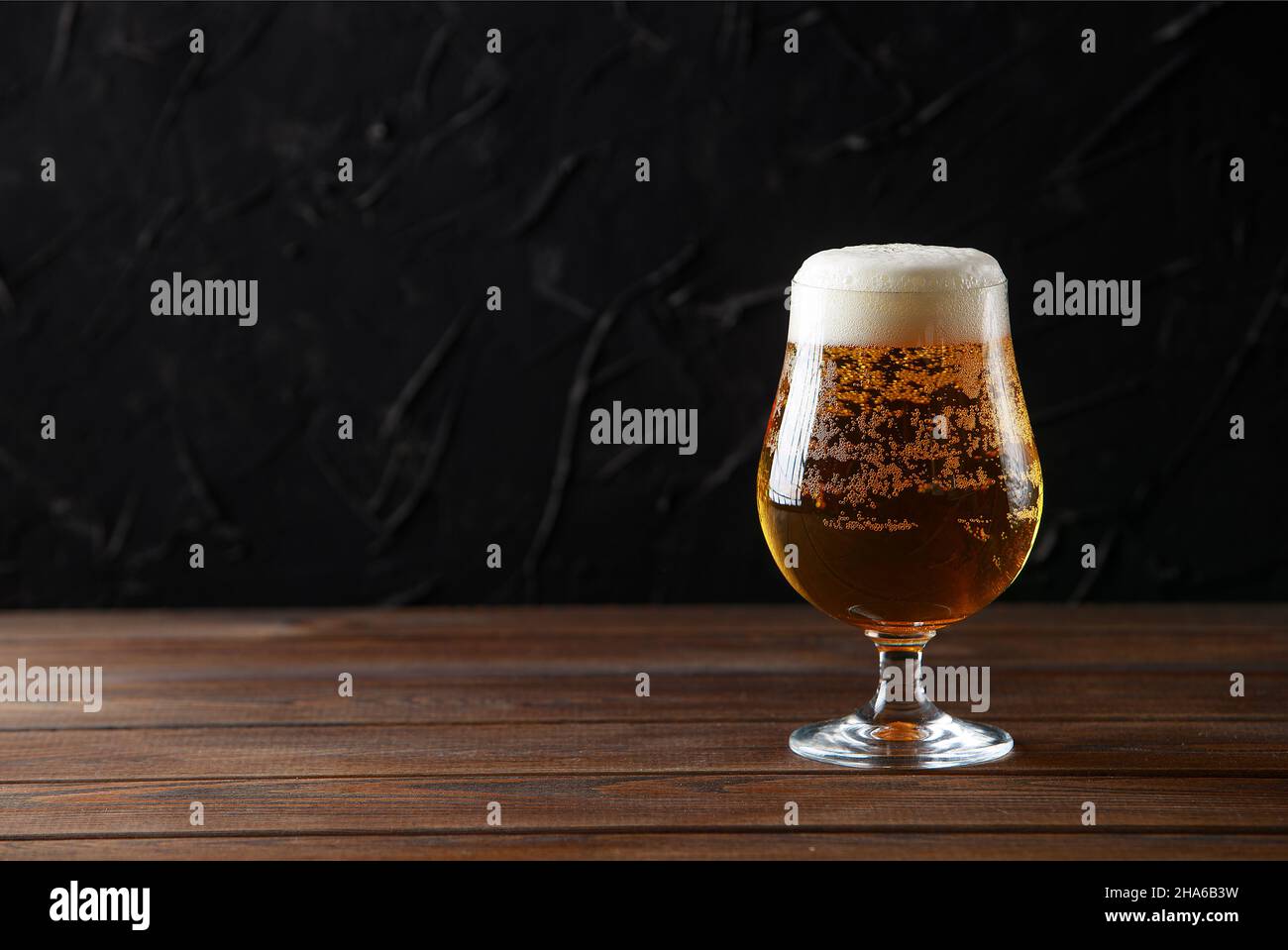 Glas Bier mit Blasen auf Holz Hintergrund mit Copyspace Stockfoto