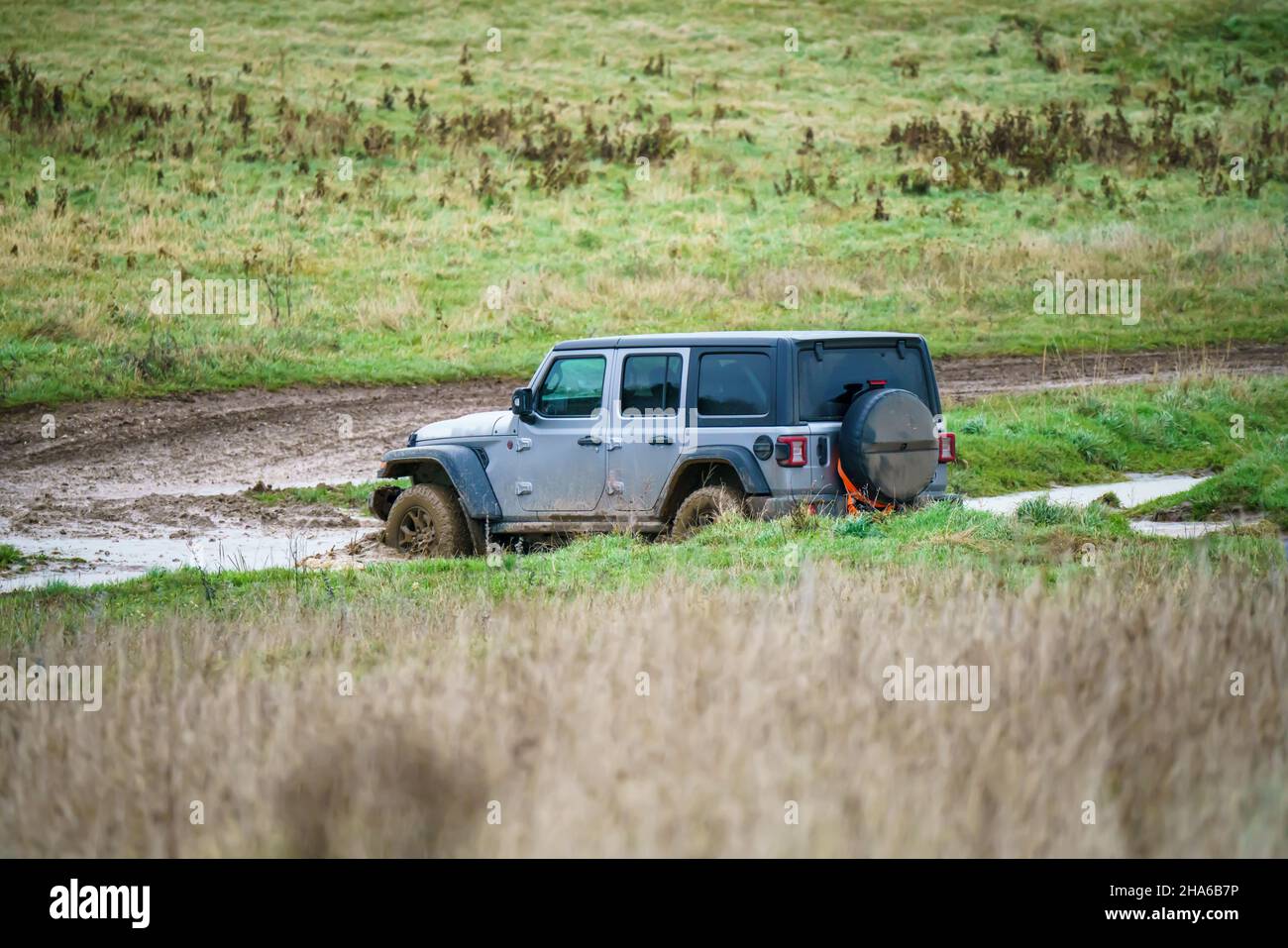 Geländewagen mit Geländewagen im Geländewagen, der über Schlamm und Wasser geloggte Gebiete fährt, Salisbury Plain Wilts UK. Jeep Rubicon Stockfoto