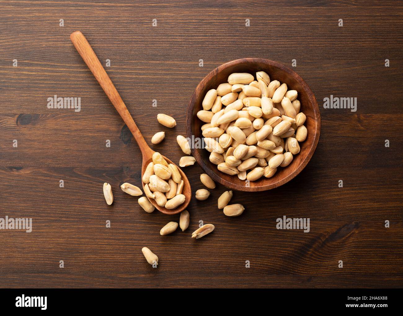 Erdnüsse in einer Holzschale auf einem Holztisch. Stockfoto