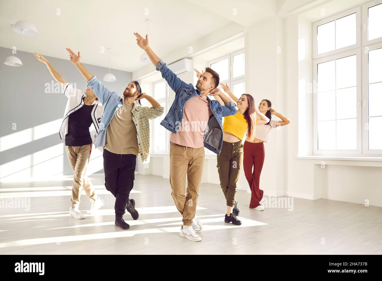 Eine Gruppe glücklicher junger Menschen, die einen zeitgenössischen Tanzkurs in einem modernen Studio haben Stockfoto