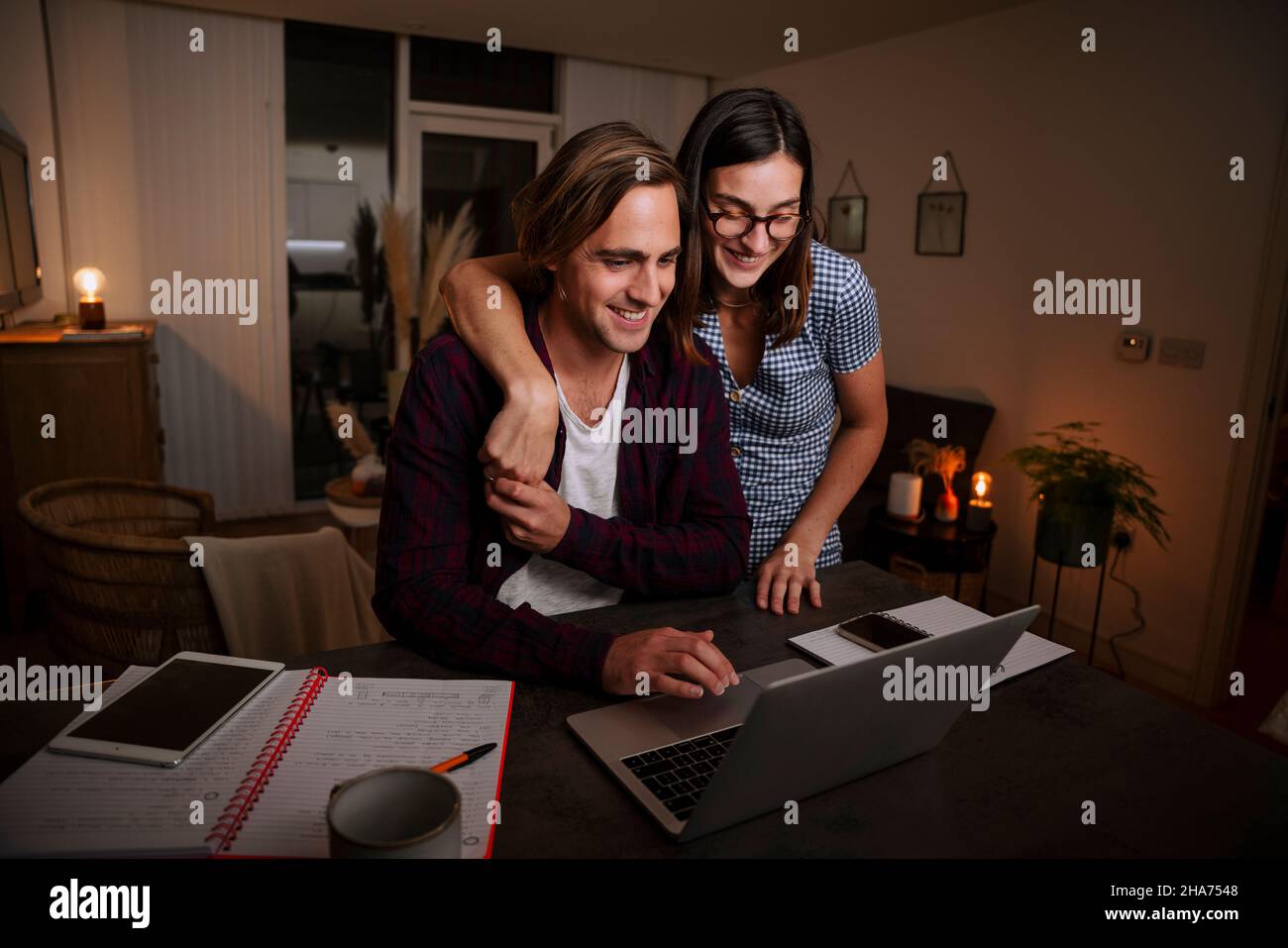 kaukasisches Ehepaar, das spät in der Nacht in der Lounge arbeitete und Zuneigung zeigte Stockfoto