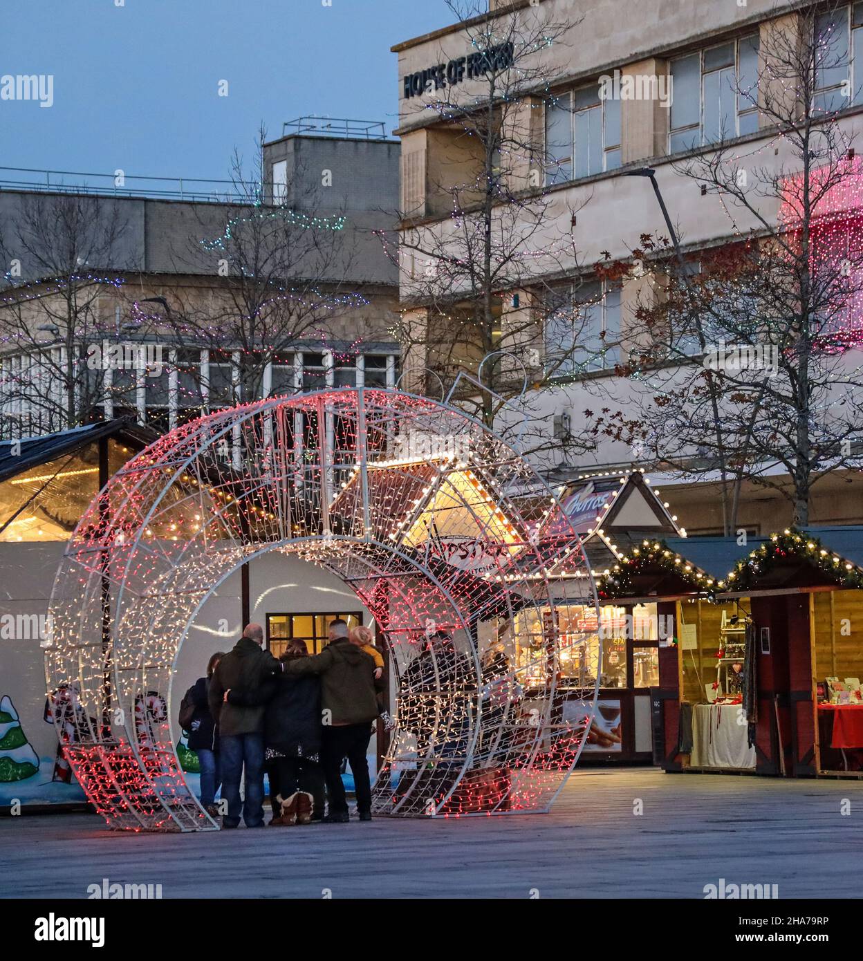Weihnachtslichter verleihen den kleinen Holzbuden auf dem Plymouth Christmas Market, wo ein leuchtender, kugelförmiger Bogen eine großartige Atmosphäre bietet, eine Wärme Stockfoto