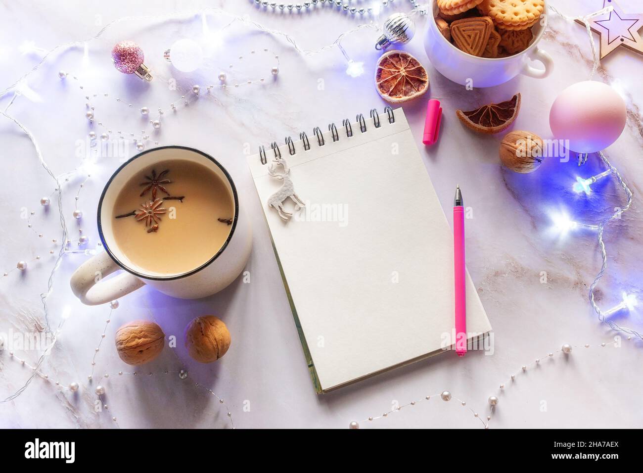 Notizbuch mit Platz für Text Kaffeetasse Konzept weihnachten Neujahr Shopping Wunschliste auf dem Hintergrund der weihnachtsdekoration glühende Girlande Stockfoto