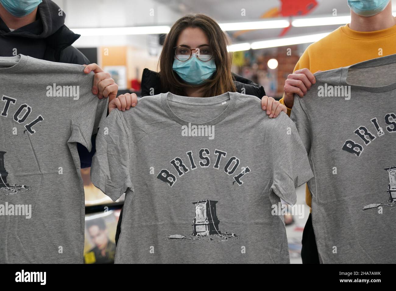 Kunden in Rough Trade in Bristol, mit einem T-Shirt des Straßenkünstlers Banksy, das verkauft wird, um vier Personen zu unterstützen, die vor Gericht gestellt werden und wegen des Verbrechens wegen des Abstürzens einer Statue des Sklavenhändlers Edward Colston angeklagt werden. Bilddatum: Samstag, 11. Dezember 2021. Stockfoto