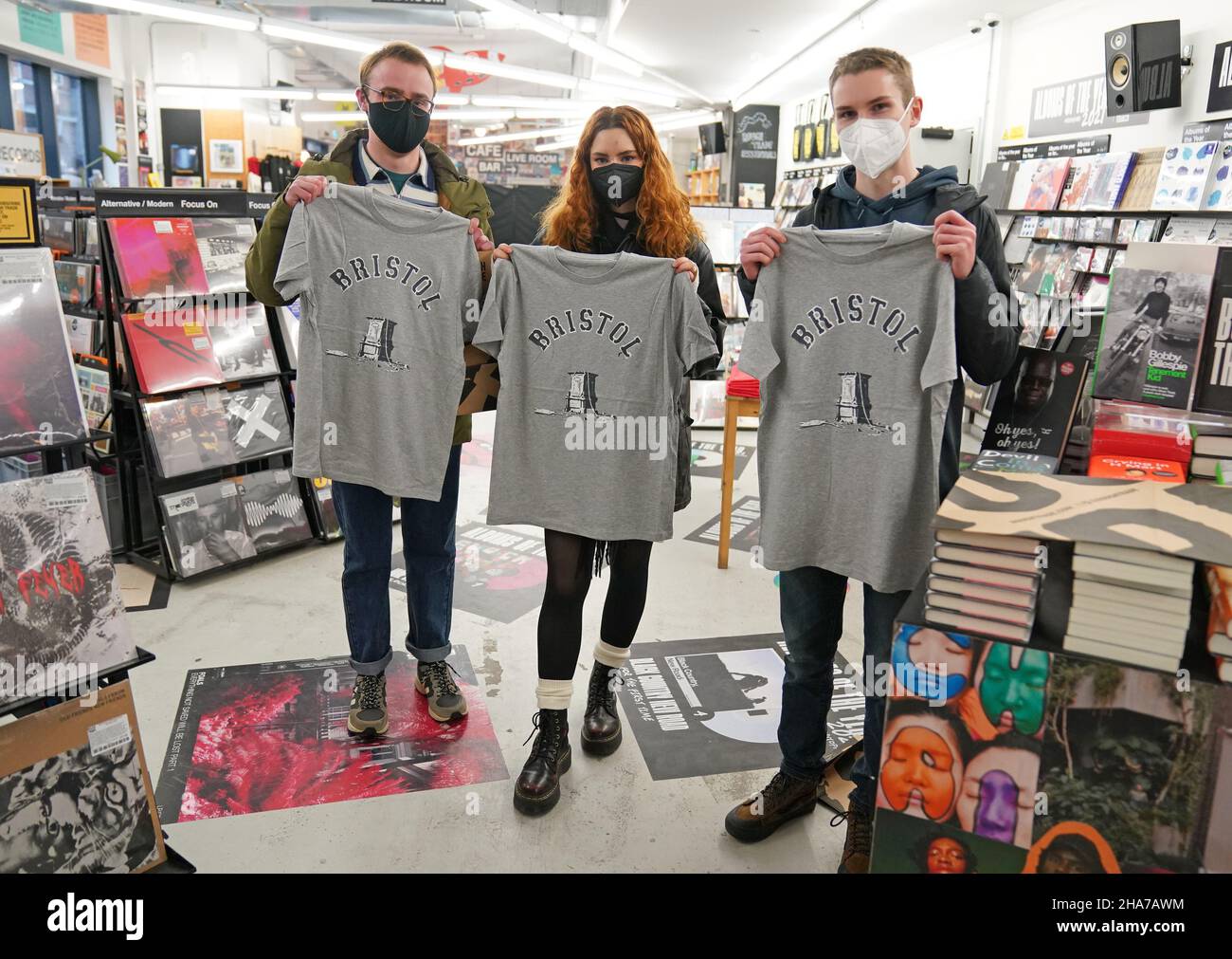 Kunden in Rough Trade in Bristol, mit einem T-Shirt des Straßenkünstlers Banksy, das verkauft wird, um vier Personen zu unterstützen, die vor Gericht gestellt werden und wegen des Verbrechens wegen des Abstürzens einer Statue des Sklavenhändlers Edward Colston angeklagt werden. Bilddatum: Samstag, 11. Dezember 2021. Stockfoto