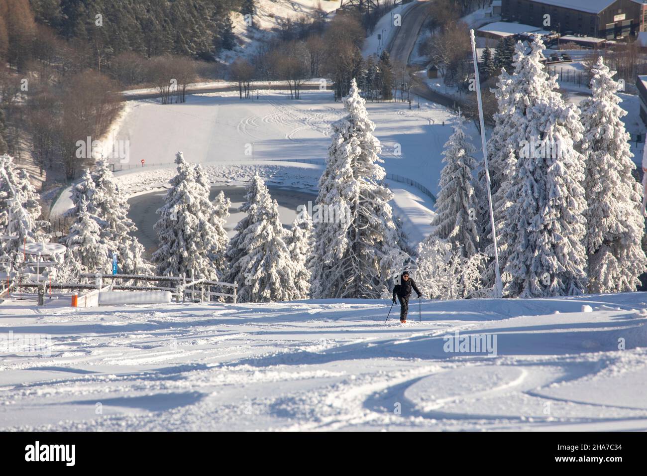 Fichtelberg, Deutschland. 11th Dez 2021. Ein Mann ist auf dem sonst menschenleeren Fichtelberg unterwegs. Die sächsischen Liftbetreiber blicken gespannt auf die kommenden Wochen. Die dramatisch hohen Corona-Infektionszahlen im Freistaat bringen schlechte Erinnerungen an das vergangene Jahr und die komplett abgesagte Saison zurück. Die Verordnung, die derzeit noch bis Dezember 12 in Kraft ist, erlaubt keinen Skibetrieb. Quelle: Bernd März/B&S/dpa/Alamy Live News Stockfoto