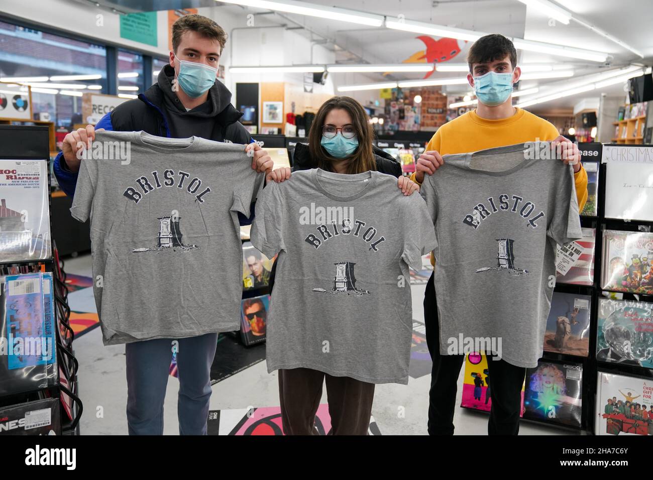 Kunden in Rough Trade in Bristol, mit einem T-Shirt des Straßenkünstlers Banksy, das verkauft wird, um vier Personen zu unterstützen, die vor Gericht gestellt werden und wegen des Verbrechens wegen des Abstürzens einer Statue des Sklavenhändlers Edward Colston angeklagt werden. Bilddatum: Samstag, 11. Dezember 2021. Stockfoto