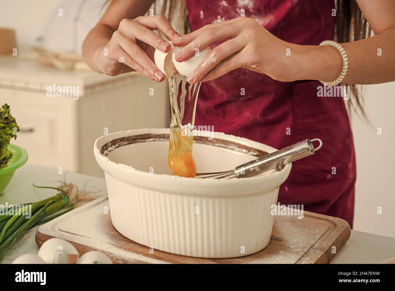 Schauen, was Kochen. Die Wahl einer Karriere. Kulinarische und Küche. Kindheit. Happy Kind tragen Koch Uniform. Chef Mädchen mit Ei. Kid Kochen Lebensmittel in der Küche Stockfoto