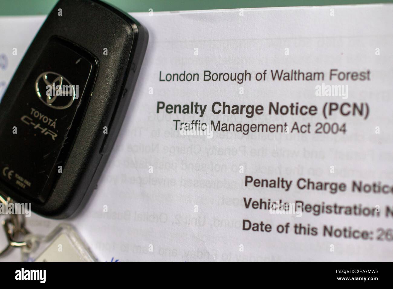 PCN, Strafgebühr, ausgestellt von London Borough of Waltham Forest für Fahrverletzungen, mit Autoschlüssel Stockfoto