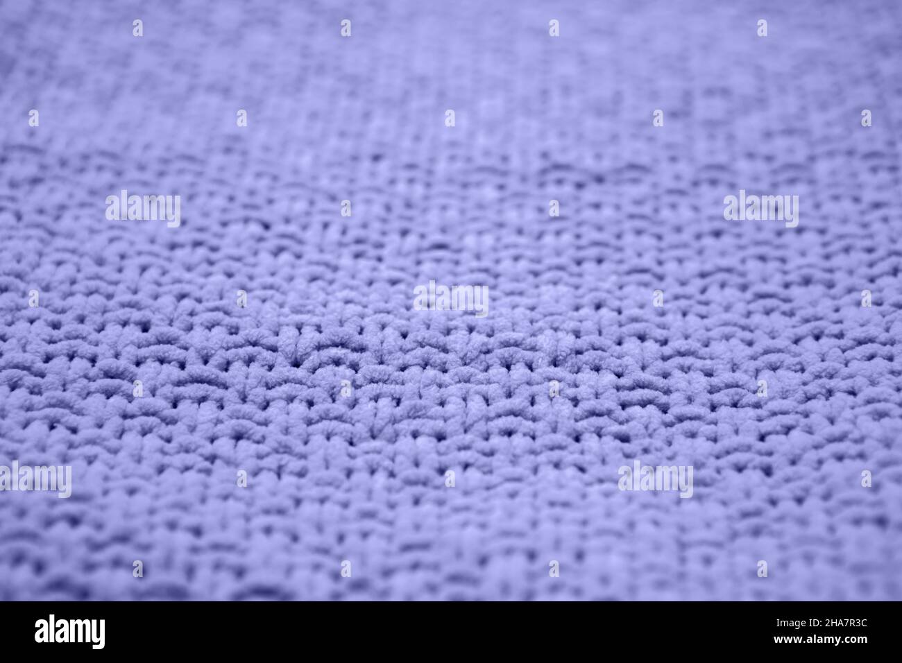 Farbe des Jahres 2022 sehr peri. Strickpullover mit Struktur in Nahaufnahme. Trendiger, weicher, abstrakter Hintergrund. Stockfoto