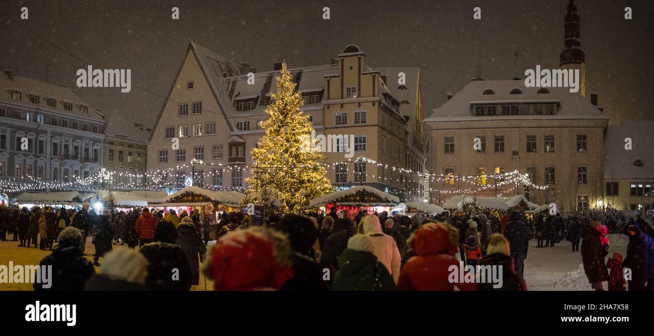 Tallinns Weihnachtsmarkt auf dem zentralen Marktplatz der Altstadt (Raekojaplats). Tallinns Rathausplatz während der Feiertage und Schneefall. Stockfoto