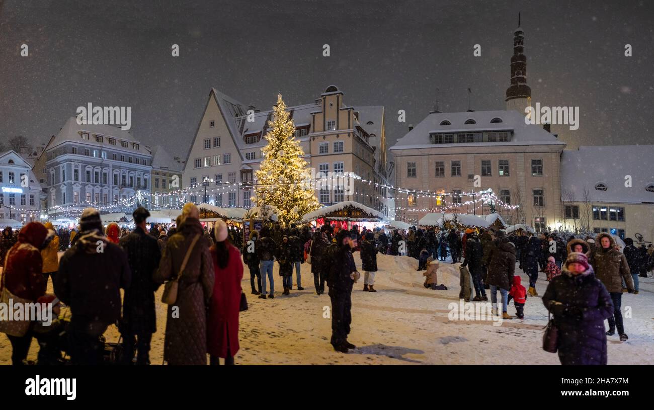 Tallinns Weihnachtsmarkt auf dem zentralen Marktplatz der Altstadt (Raekojaplats). Tallinns Rathausplatz während der Feiertage und Schneefall. Stockfoto