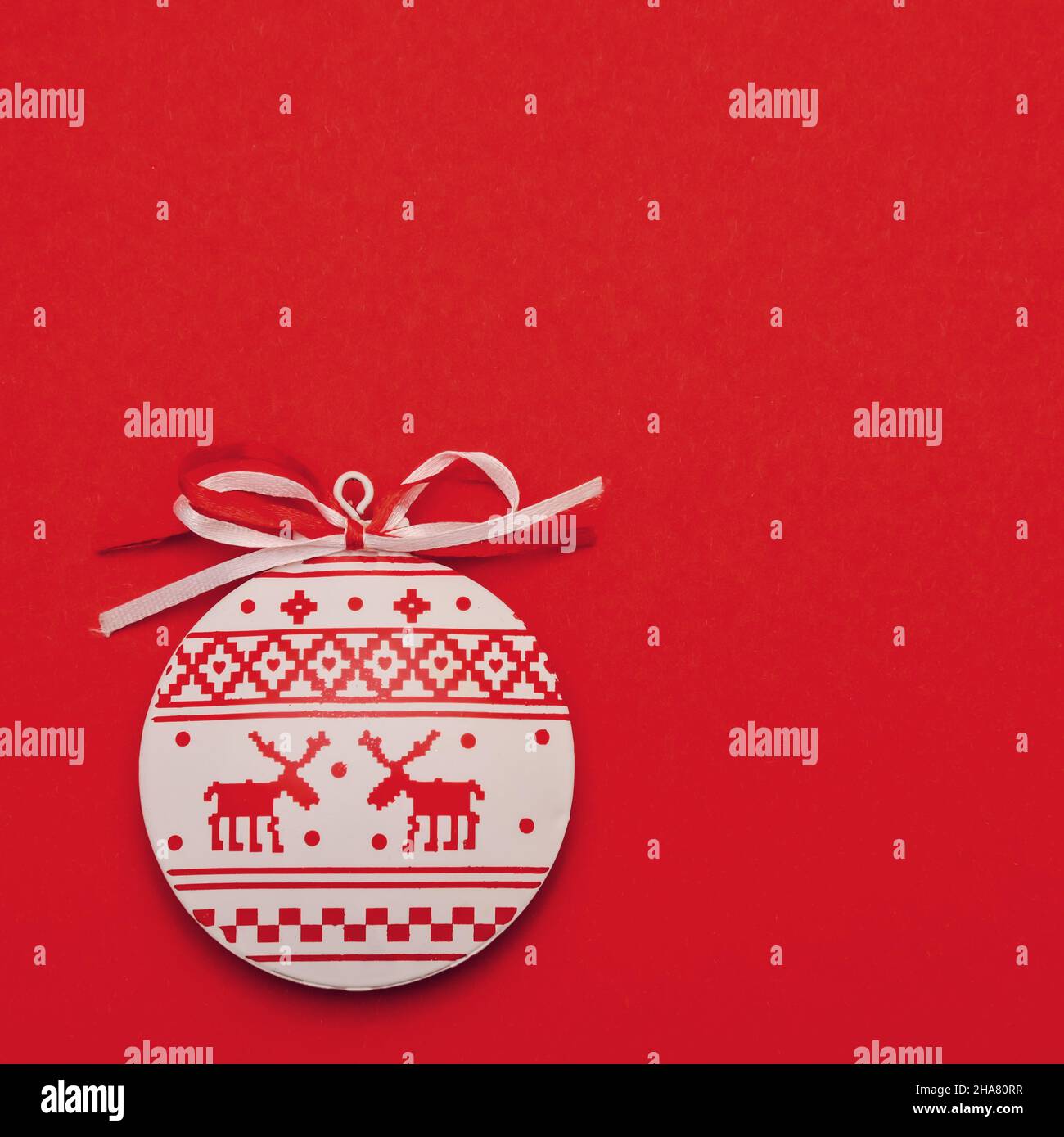 Flaches weißes rotes weihnachtsspielzeug mit minimalistischer runder Kugel im nordischen Stil auf hellrotem Hintergrund mit Platz zum Kopieren Stockfoto