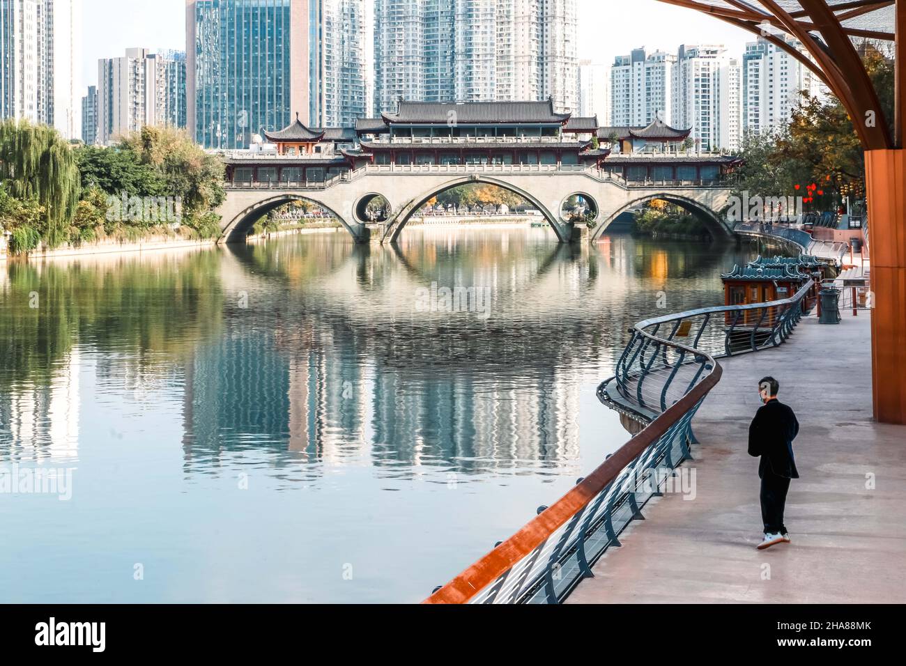 Älterer Mann praktiziert Tai Chi am Jinjiang Fluss mit Blick auf die ikonische Anshun Brücke in Chengdu, einer Megastadt in Sichuan, China - bekannt für ihre RE Stockfoto