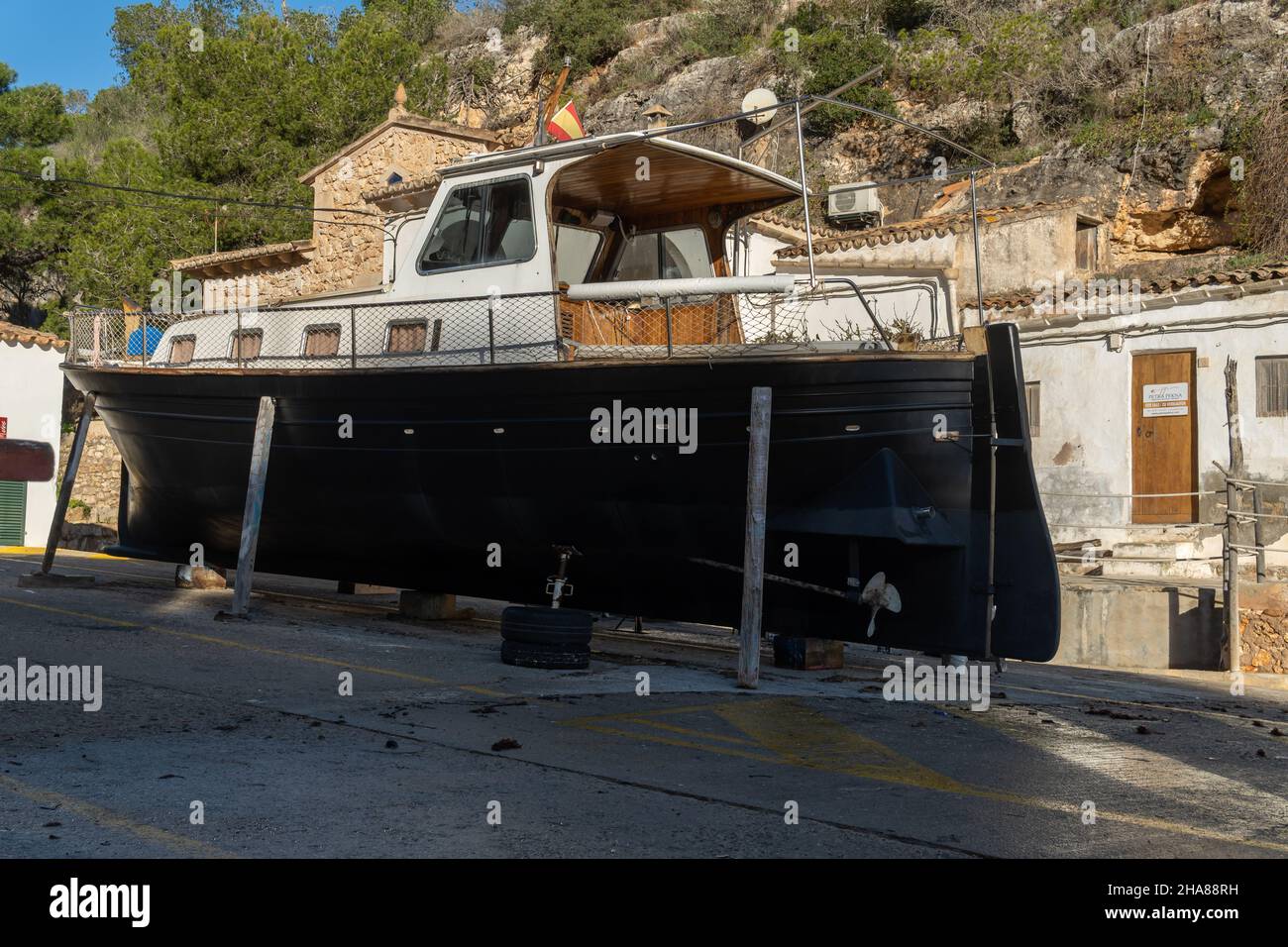 Freizeitboot unterstützt auf Metallstativen für zukünftige Restaurierung. Cala Figuera Marina, Insel Mallorca, Spanien Stockfoto