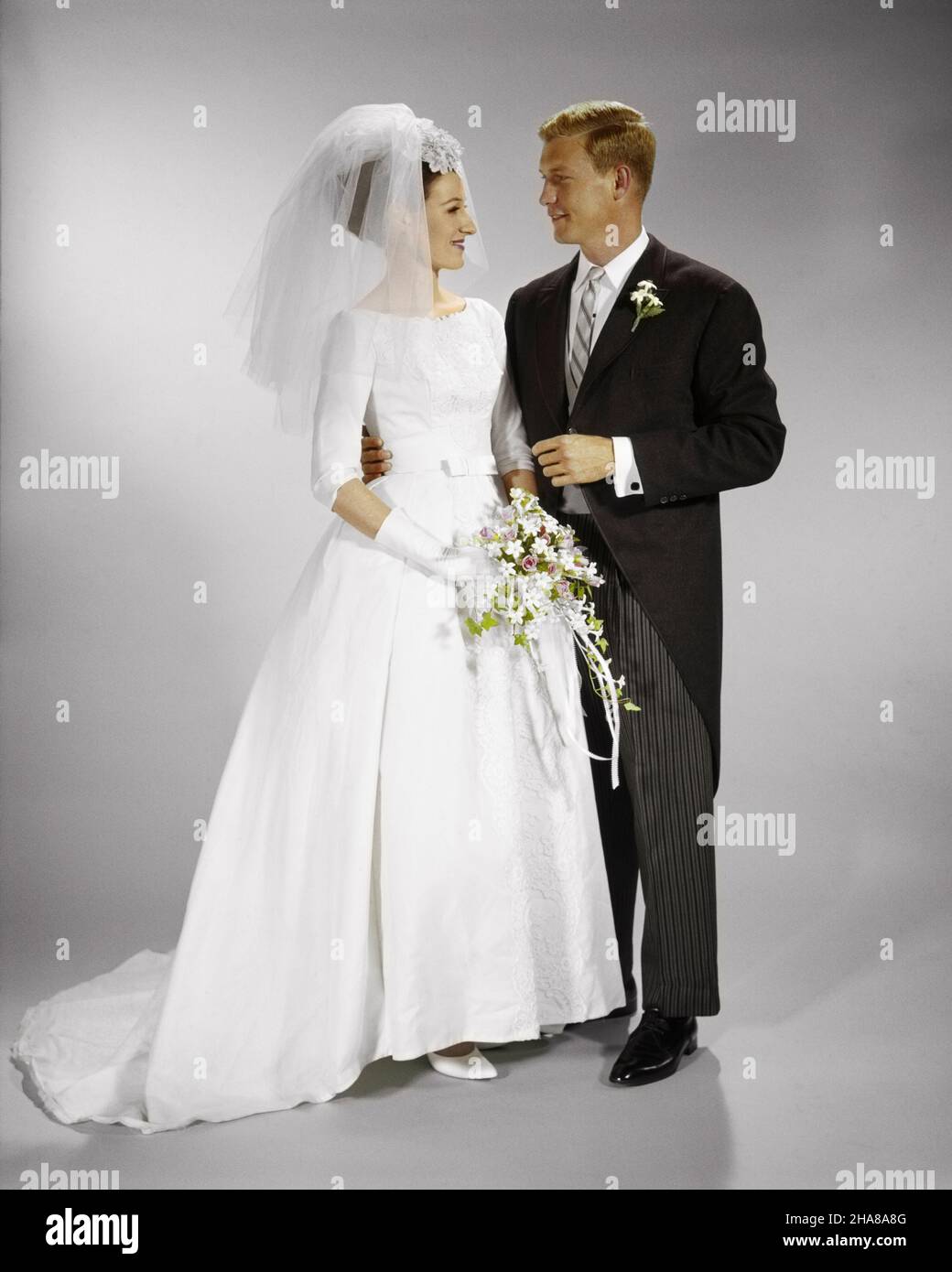 1960S PORTRÄT VON BRAUT UND BRÄUTIGAM NEBENEINANDER - KB5520 HAR001 HARS LIFESTYLE-FEIER FRAUEN VERHEIRATET STUDIOAUFNAHME ROSEN EREIGNIS EHEPARTNER EHEMÄNNER KOPIEREN RAUM FREUNDSCHAFT IN VOLLER LÄNGE DAMEN EHE PERSONEN INSPIRATION FÜRSORGLICHE MÄNNER SCHLEIER VERTRAUEN ZEREMONIE PARTNER BRAUT TRÄUME GLÜCK ABENTEUER BRÄUTE STILE BRAUCH UND AUFREGUNG TRADITION NUPTIAL NUPTIALS ANLASS HEIRAT STOLZ BEZIEHUNGEN VERBINDUNG KONZEPTIONELLEN RITUS DER PASSAGE STILVOLL MI MORGEN MANTEL PERSÖNLICHE BINDUNG ZUNEIGUNG ZUSAMMENARBEIT EMOTION MODEN HEIRATEN EHE MITTE ERWACHSENE MITTE ERWACHSENE MANN MITTE ERWACHSENE FRAU ZWEISAMKEIT Stockfoto