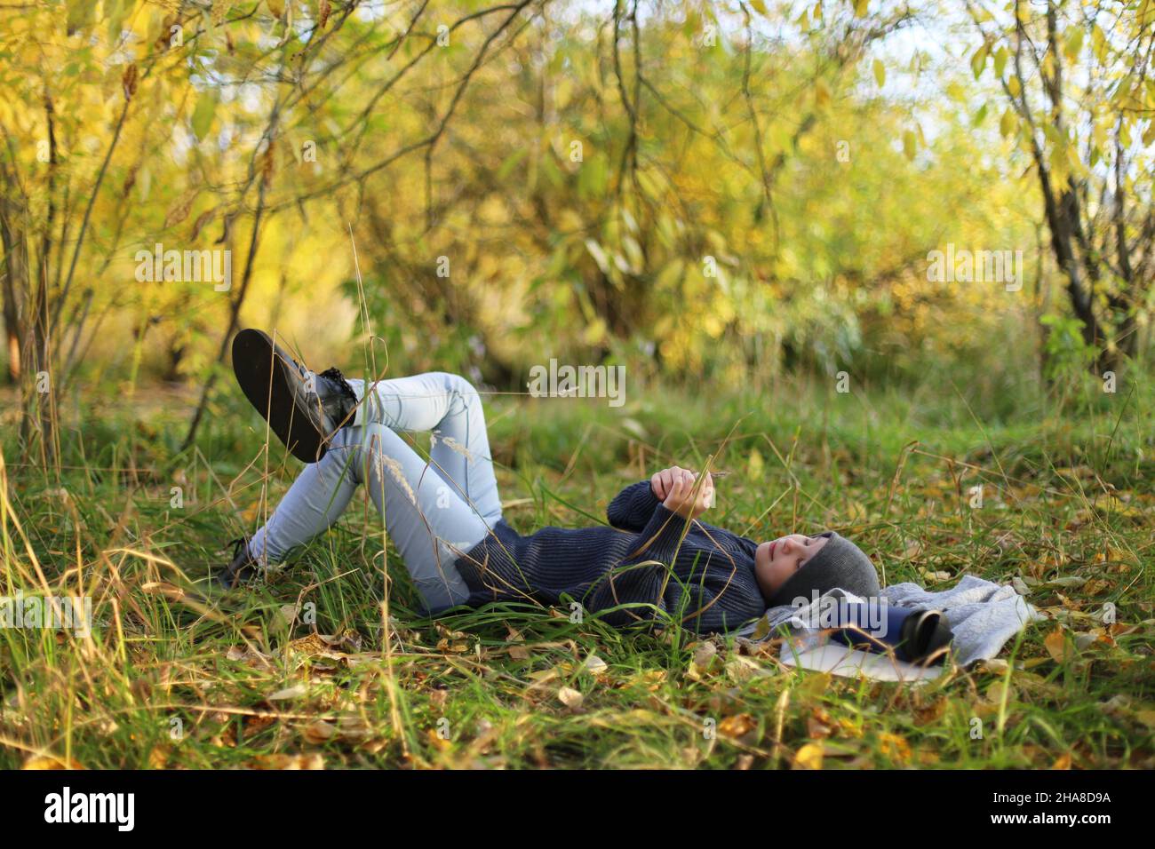 Teenager liegt auf dem Gras und ruht im Park Stockfoto