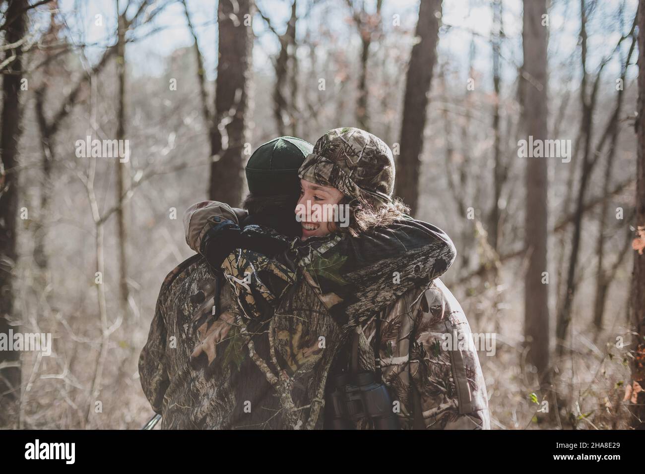 Vater und Sohn Hirsch Jäger umarmt in Wäldern Stockfoto
