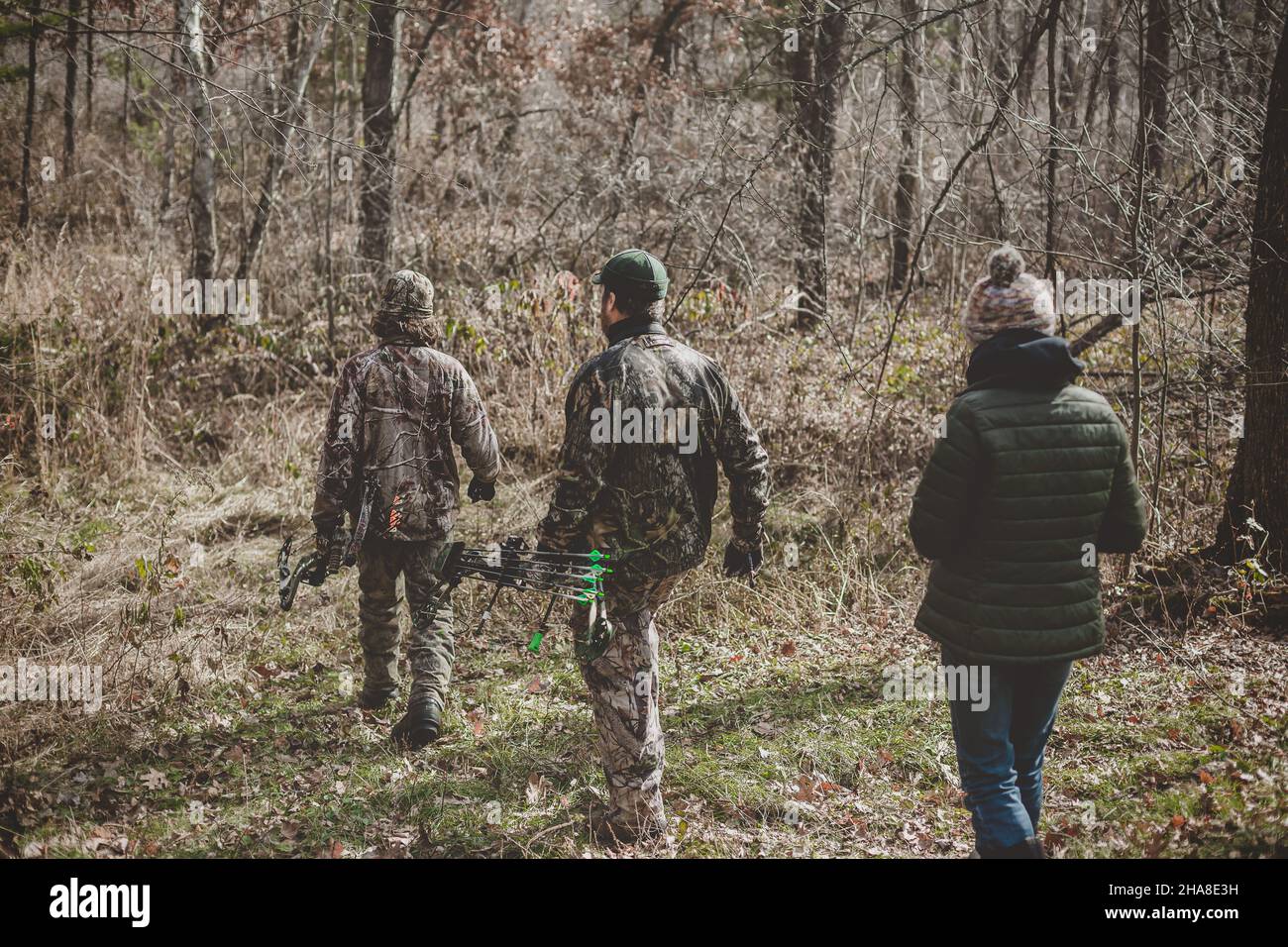 Vater und seine beiden Teenager, die in den Wald gehen, um Hirsche aufzuspüren Stockfoto