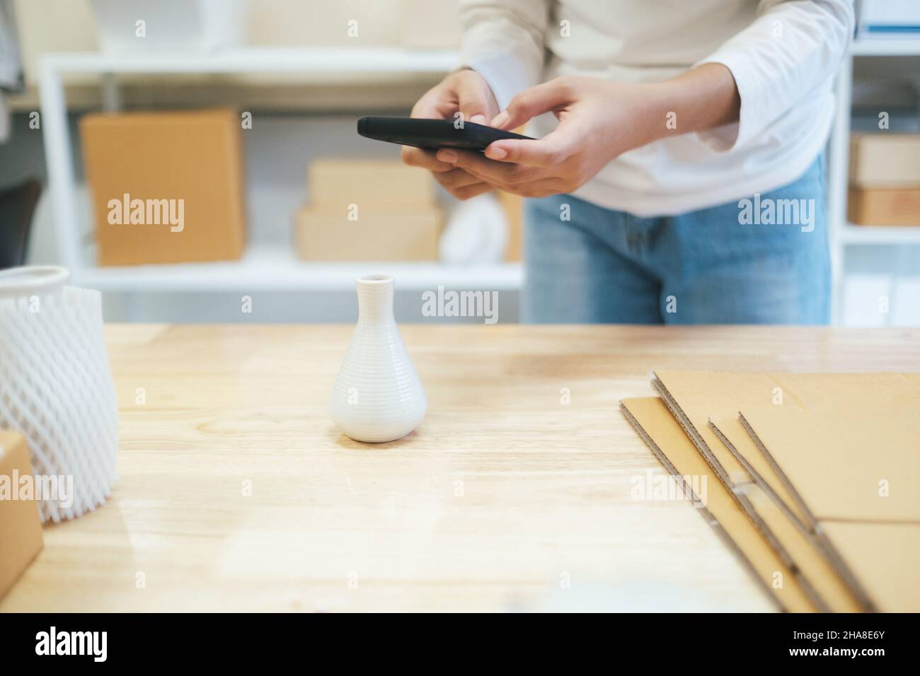 On-line-Verkäufer Besitzer ein Foto des Produkts für den Upload online shop Website. Online Verkaufen, Online-Shopping und e-Commerce Konzept. Stockfoto