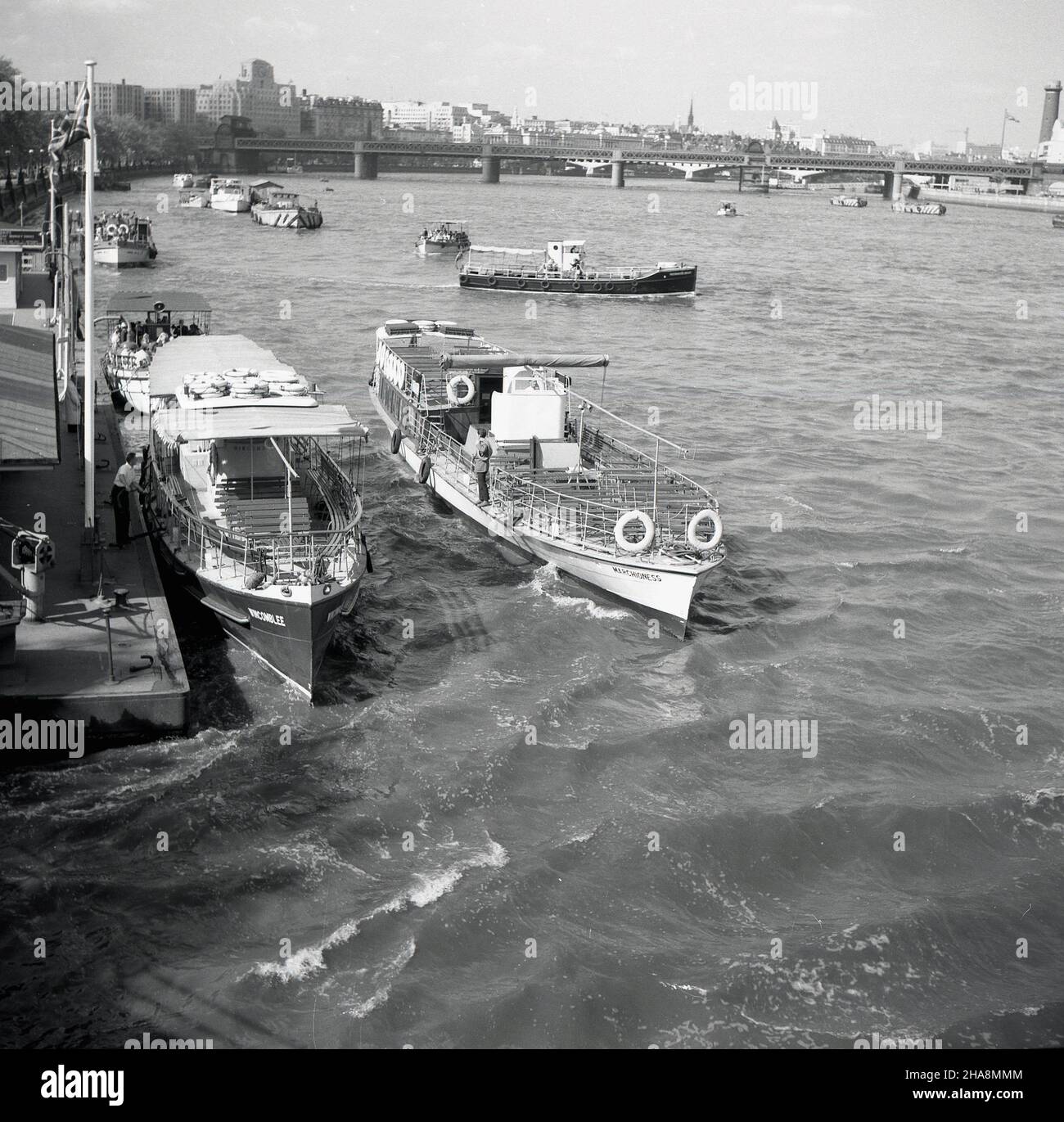 1958, historische Flussfahrtschiffe der Zeit am Steg am Westminster Pier, auf der Themse an der Westminster Bridge, London, England, Großbritannien. Die Wincomblee (1960 in Tower Belle umbenannt) befindet sich am Steg und daneben ein weiteres Boot, die Marchioness. Diese traditonellen Kreuzfahrer führten öffentliche Vergnügungsfahrten flussabwärts nach Greenwich und flussabwärts durch, manchmal bis Hampton Court. Stockfoto