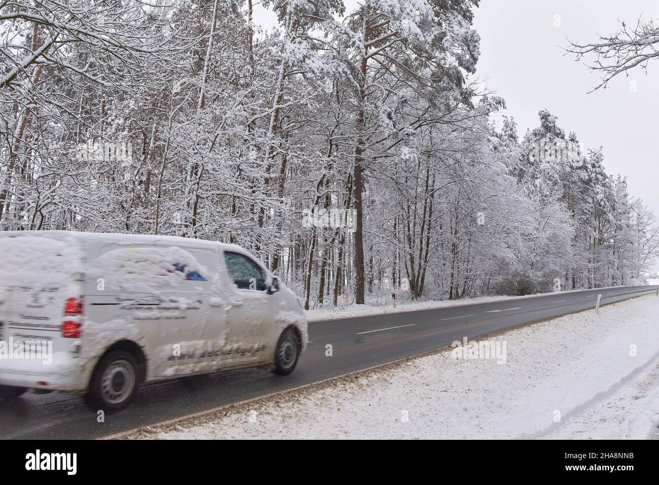 Kleinbus fährt bei schneebedecktem Wetter Stockfoto