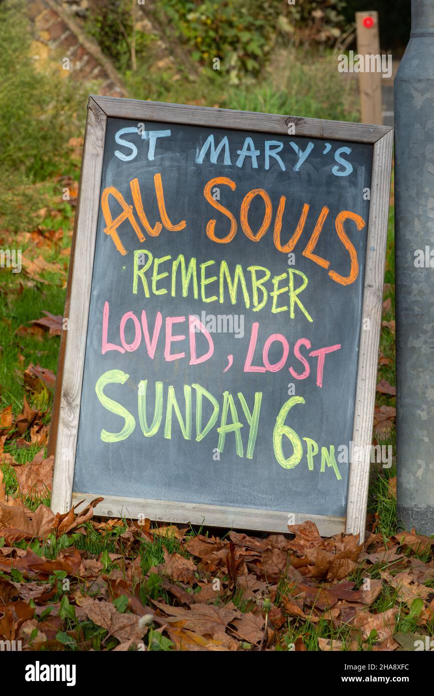 Hinweis an der Tafel über den All Souls Day vor einer Kirche in Surrey, Großbritannien. Erinnern Sie sich geliebt verloren. Stockfoto