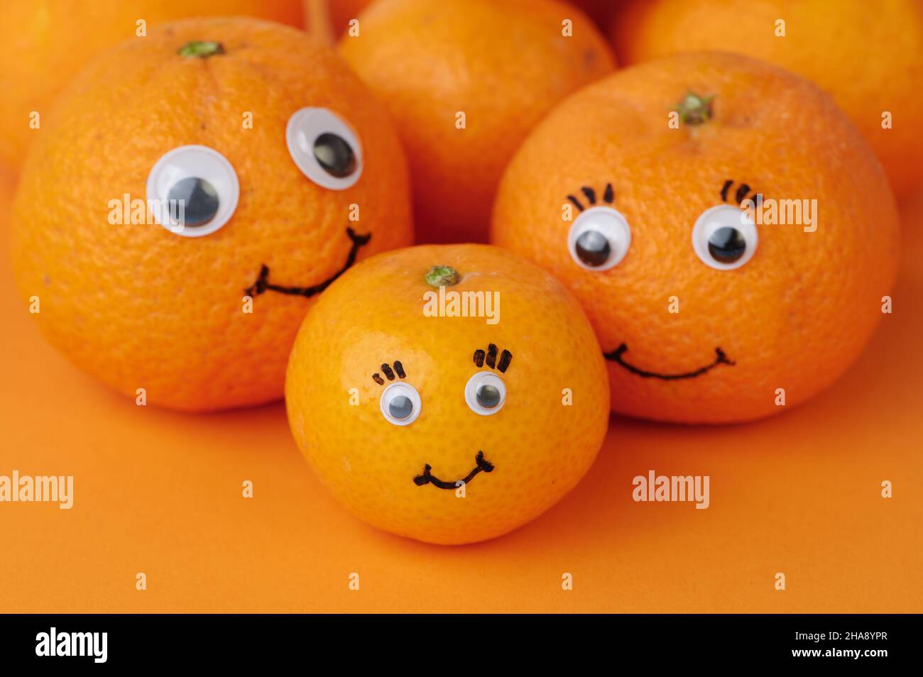 Mandarinenfamilie auf orangefarbenem Hintergrund Stockfoto