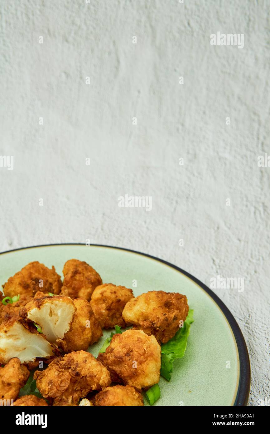 Vegane Blumenkohlbüffelflügel auf weißem Hintergrund.leckeres vegetarisches Essen Draufsicht. Knusprige gebratene Blumenkohlbisse Stockfoto