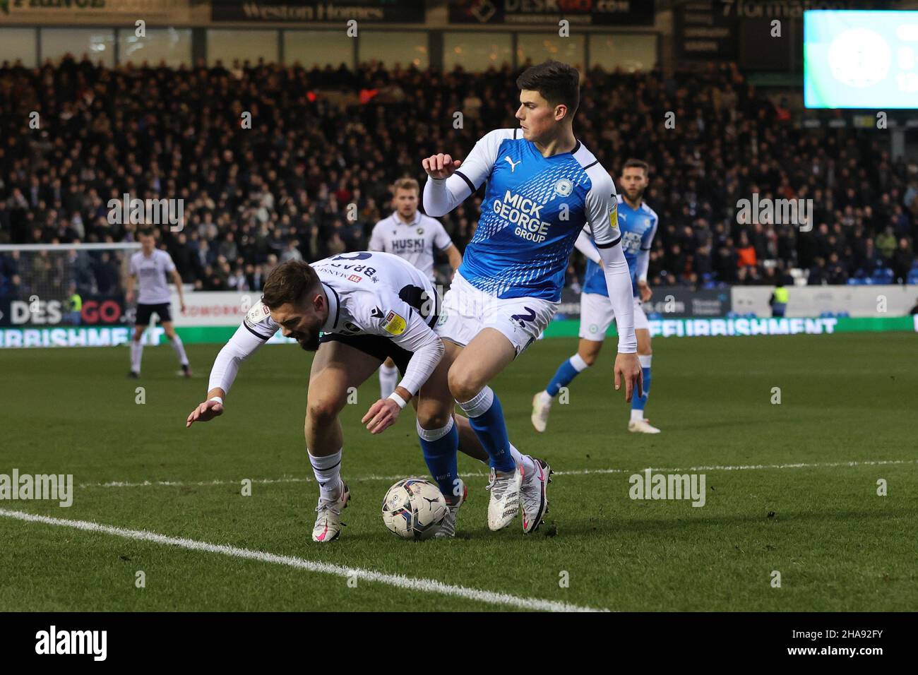 PETERBOROUGH, GBR. DEZ 11TH. Ronnie Edwards von Peterborough United und Tom Bradshaw von Millwall treffen sich während des Sky Bet Championship-Spiels zwischen Peterborough United und Millwall in der London Road, Peterborough, am Samstag, dem 11th. Dezember 2021. (Kredit: James Holyoak | MI News) Kredit: MI Nachrichten & Sport /Alamy Live News Stockfoto