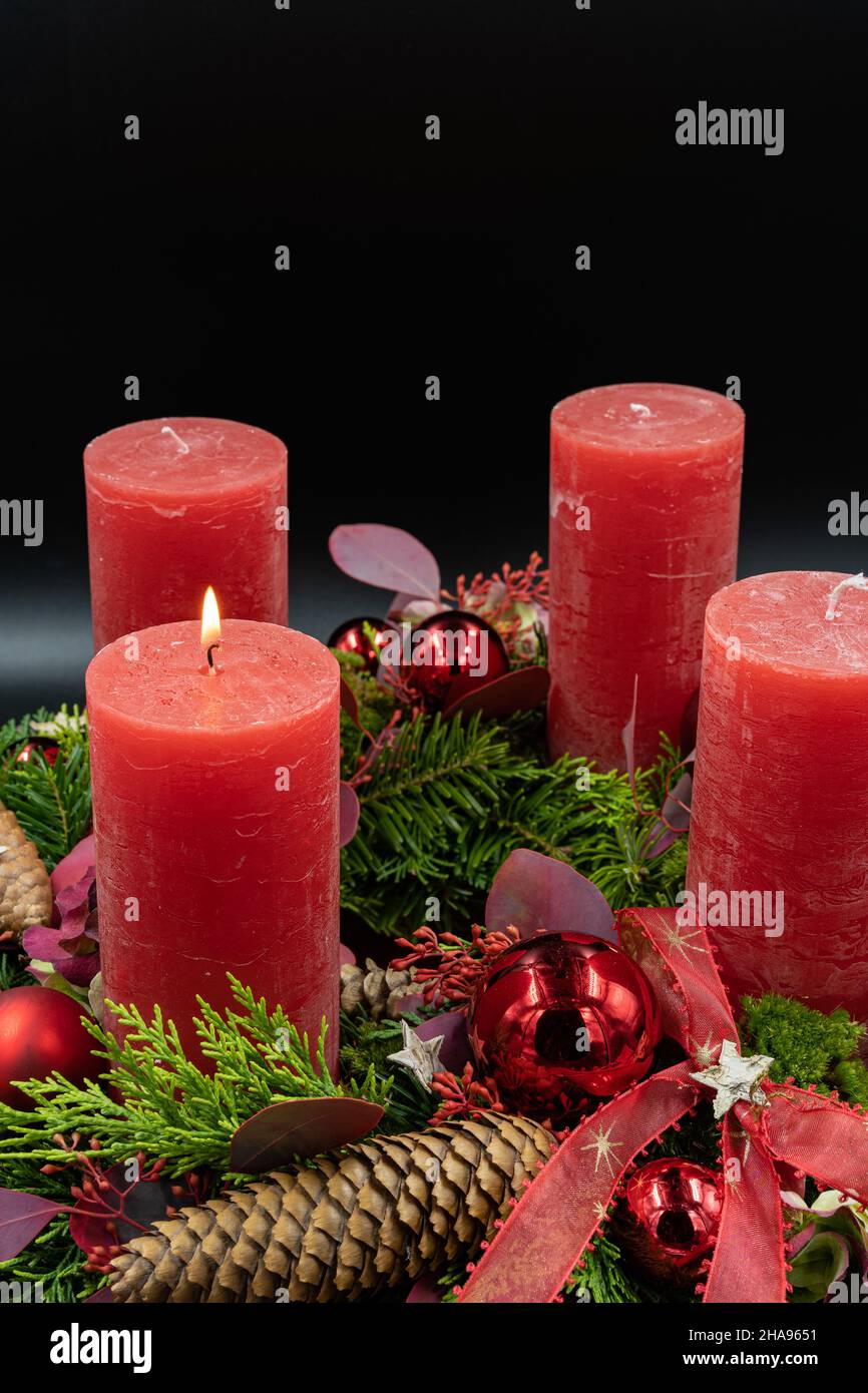 Niedrige Ansicht des schönen Adventskranzes mit einer brennenden Kerze auf schwarzem Hintergrund Stockfoto