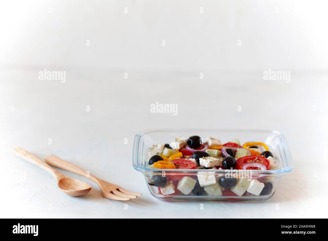 Griechischer Salat in einem Glasbehälter, Konzept des Essens bei der Arbeit Stockfoto