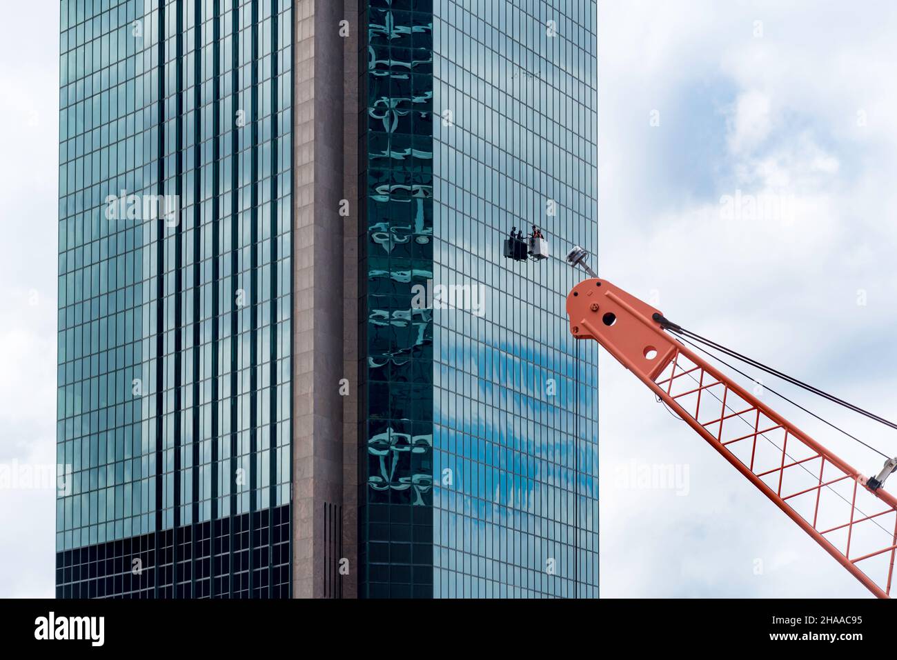 Zwei Männer, die in einer hängenden Gondel arbeiten, eine Fensterputzplattform, die an einer Glasvorhang-Wand am Gateway Building in Sydney, Australien, hing Stockfoto