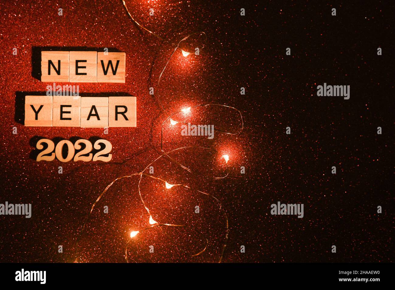 Neujahr 2022. Holzbuchstaben auf Blöcken. Auf rotem Hintergrund Stockfoto