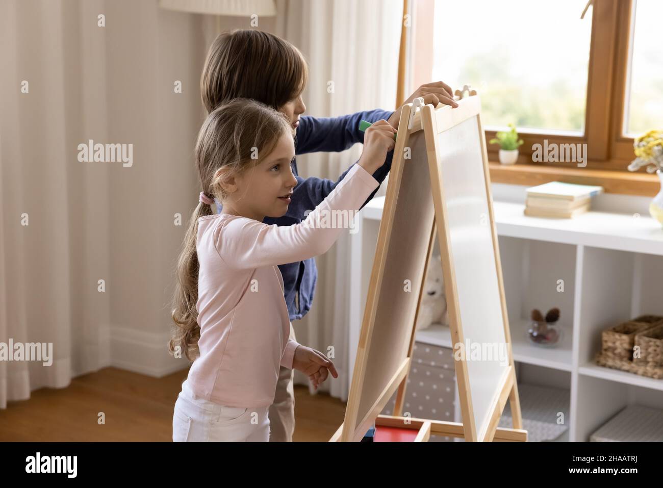 Zwei niedliche Geschwister Kinder Zeichnung auf Spielzeug kleine kindliche Whiteboard Stockfoto