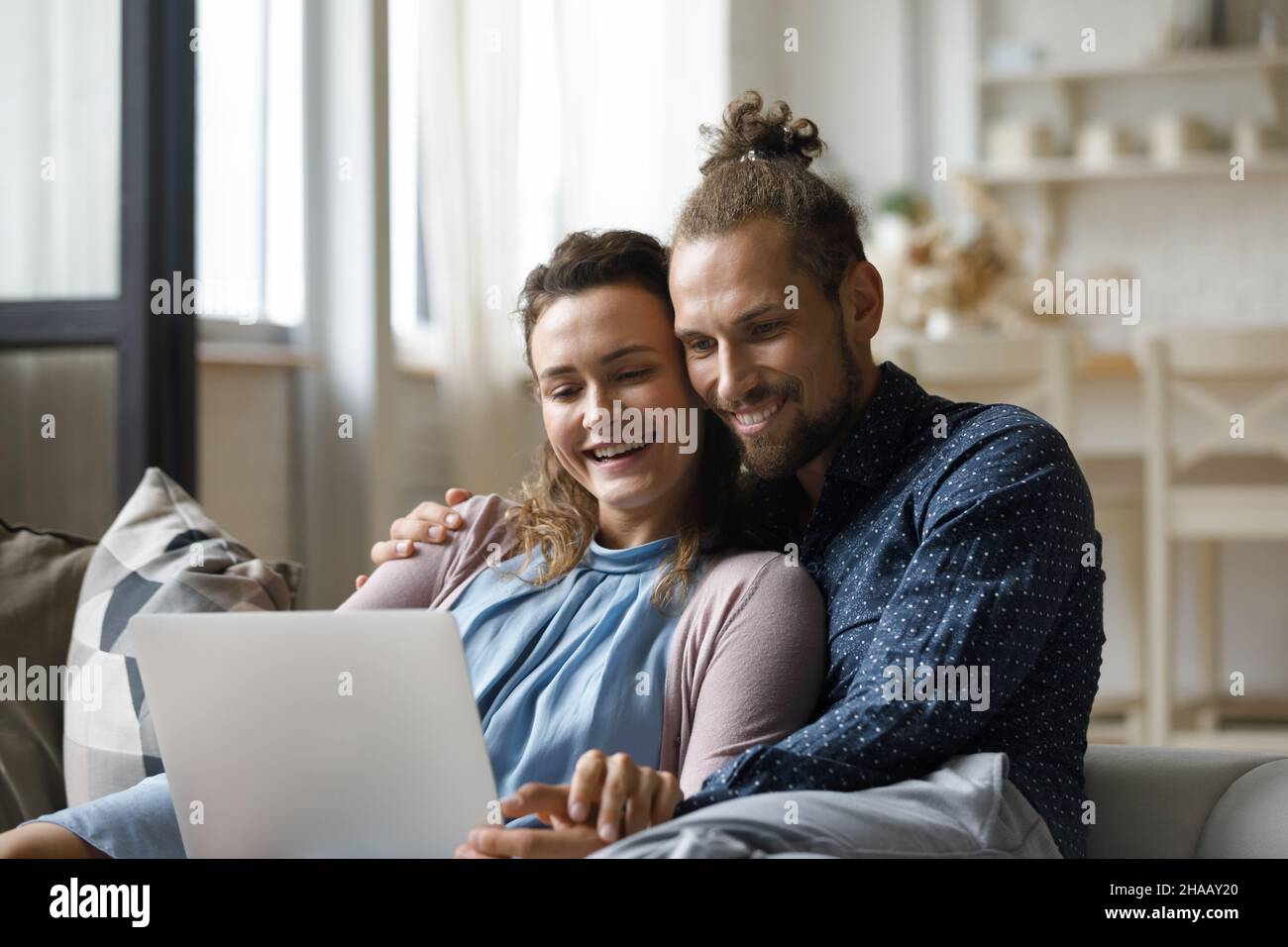 Fröhliches Familienpaar, das sich einen Film auf dem Laptop ansieht Stockfoto