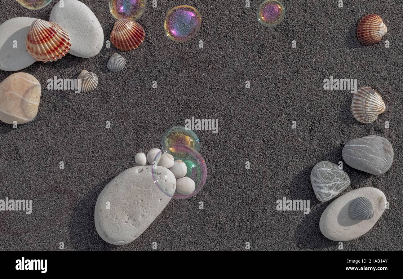 Hintergrund Seesandkörner. Platz für Text. Kieselsteine in Form eines kleinen Fußes, um eine Geburt anzukündigen. Stockfoto