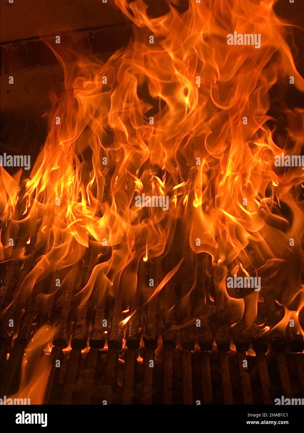 Brennender Kamin mit Feuerflammen auf schwarzem Hintergrund. Flammen brennen in einem Holzfeuer. Stockfoto