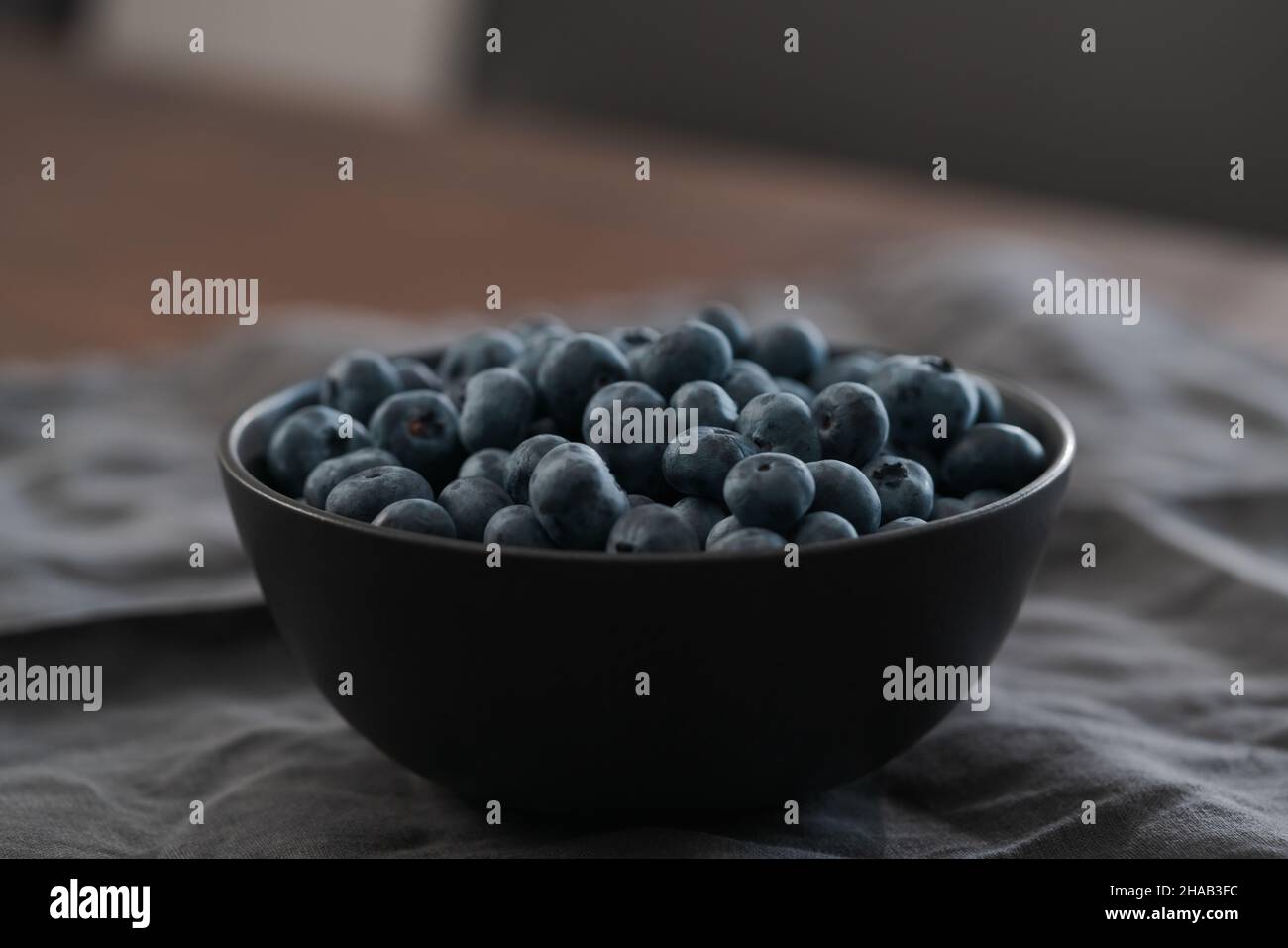 Große Schüssel mit Heidelbeeren auf dem Tisch, flacher Fokus Stockfoto